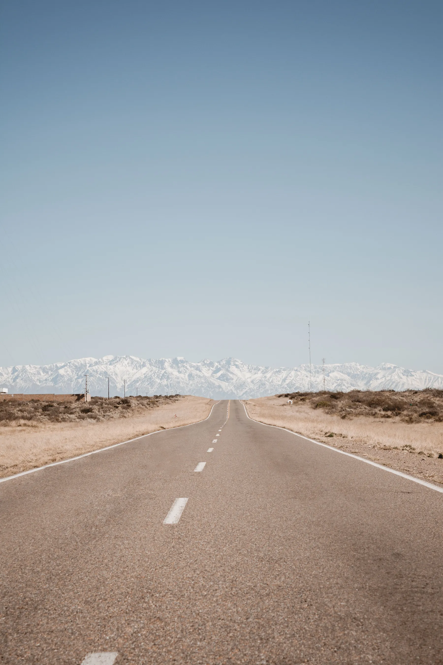 A long straight road leading towards mountains in Mendoza.
