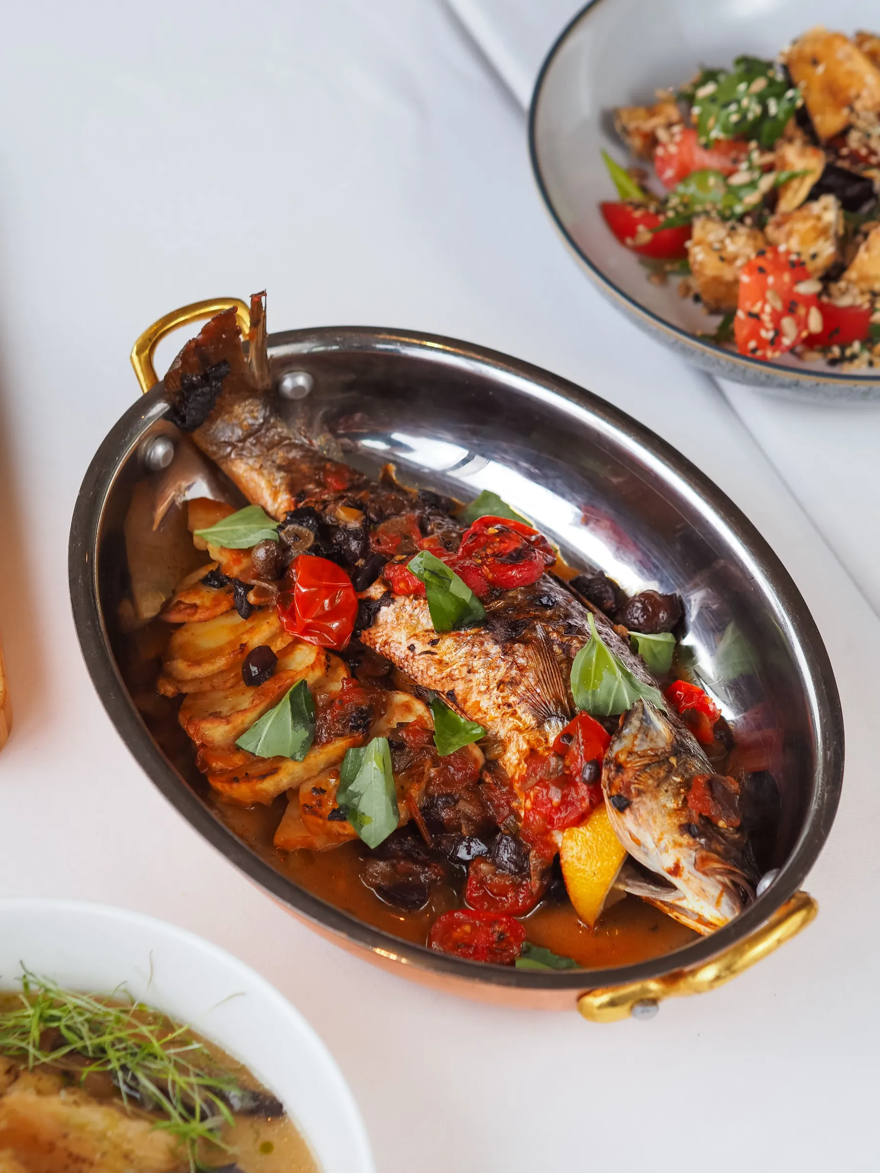 Cooked fish with roasted vegetables and lemon on a serving platter