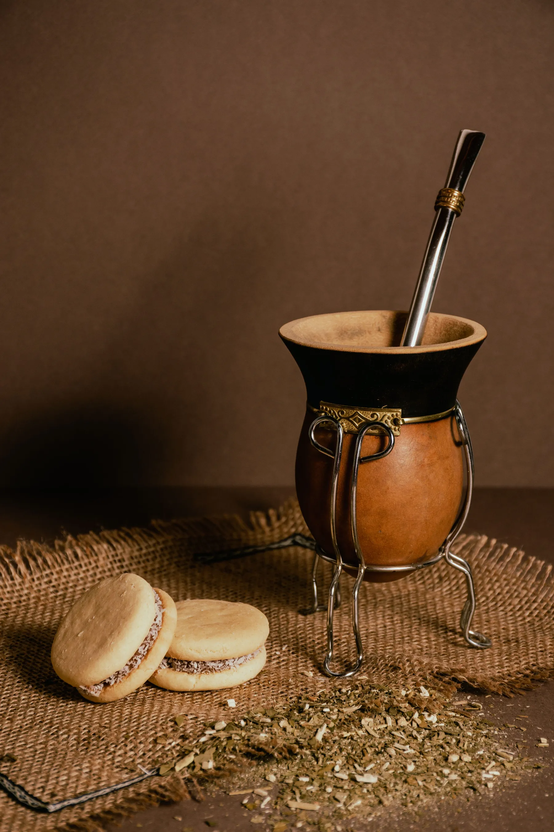 A mate cup and alfajores on a rustic table setting.