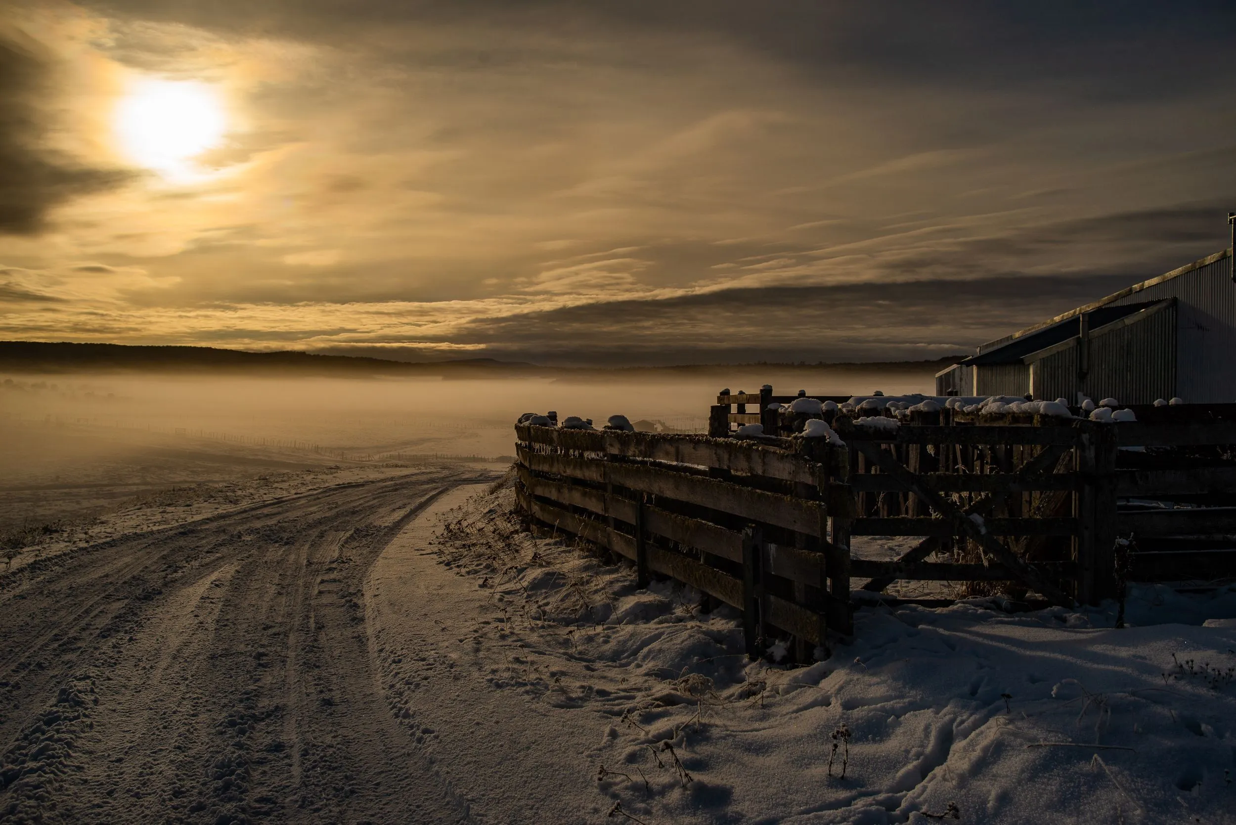 Low winter sunlight across a snowy rural scene near Tolhuin.