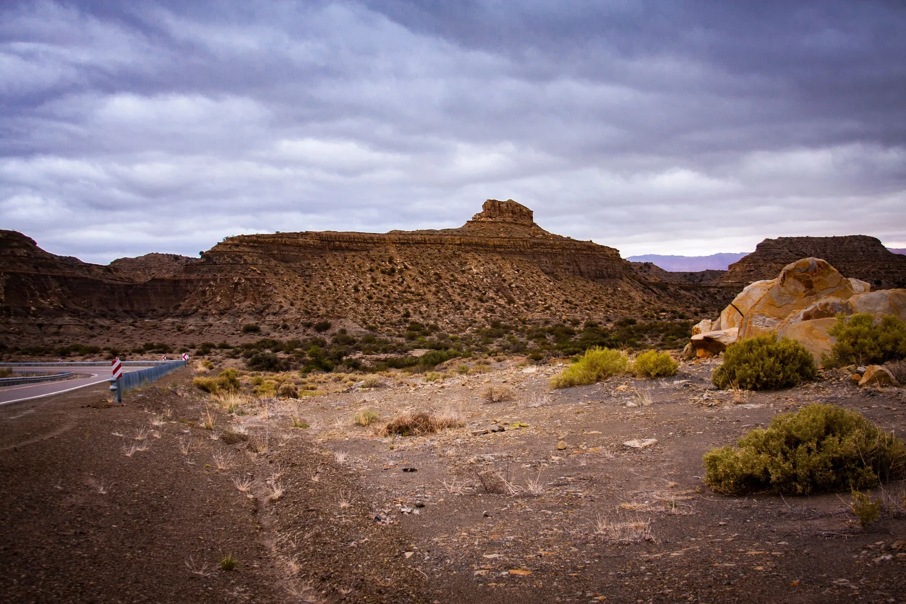 Arid San Juan rock formations beneath heavy clouds