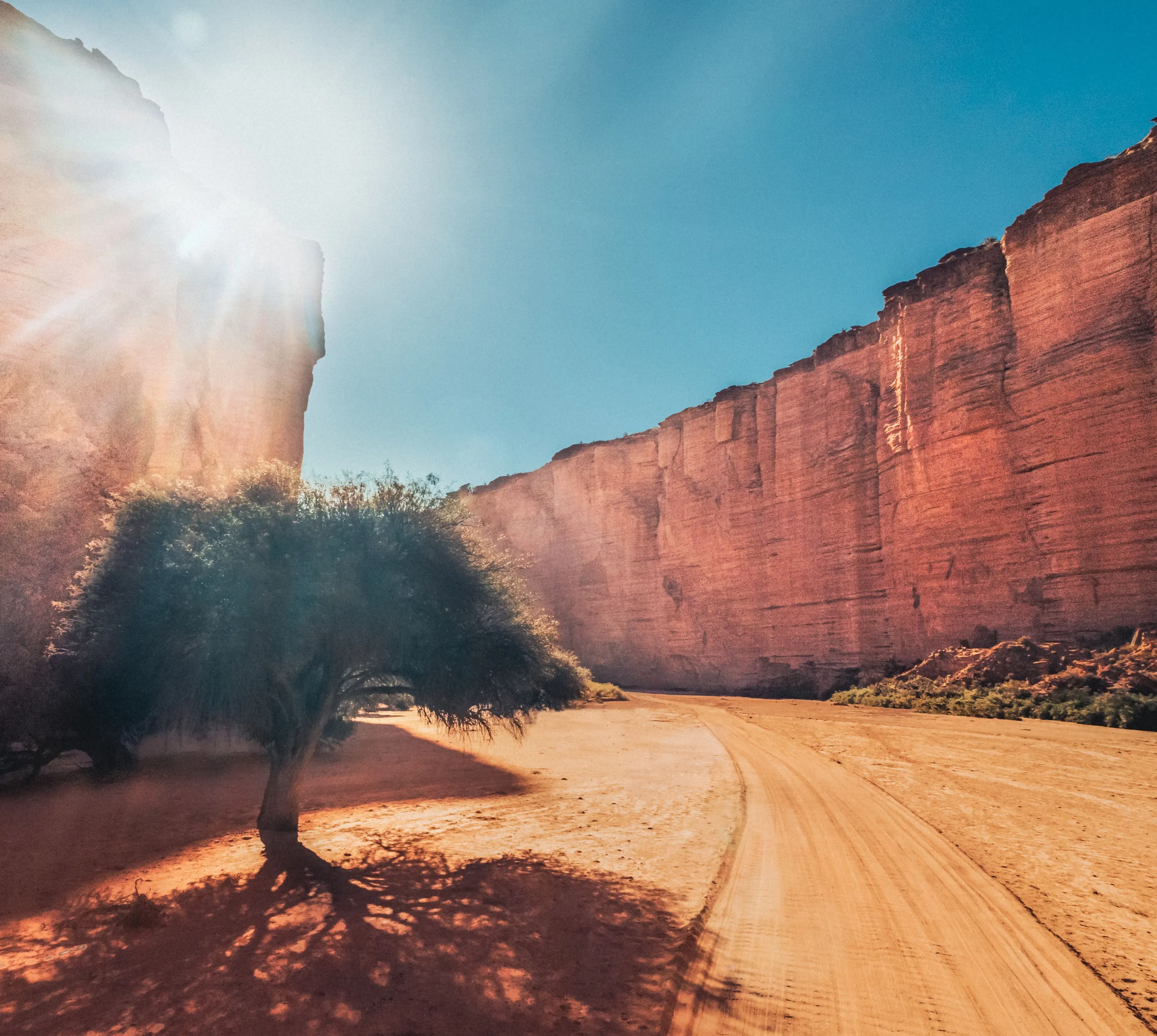 Sunlight breaks into a red sandstone canyon in La Rioja