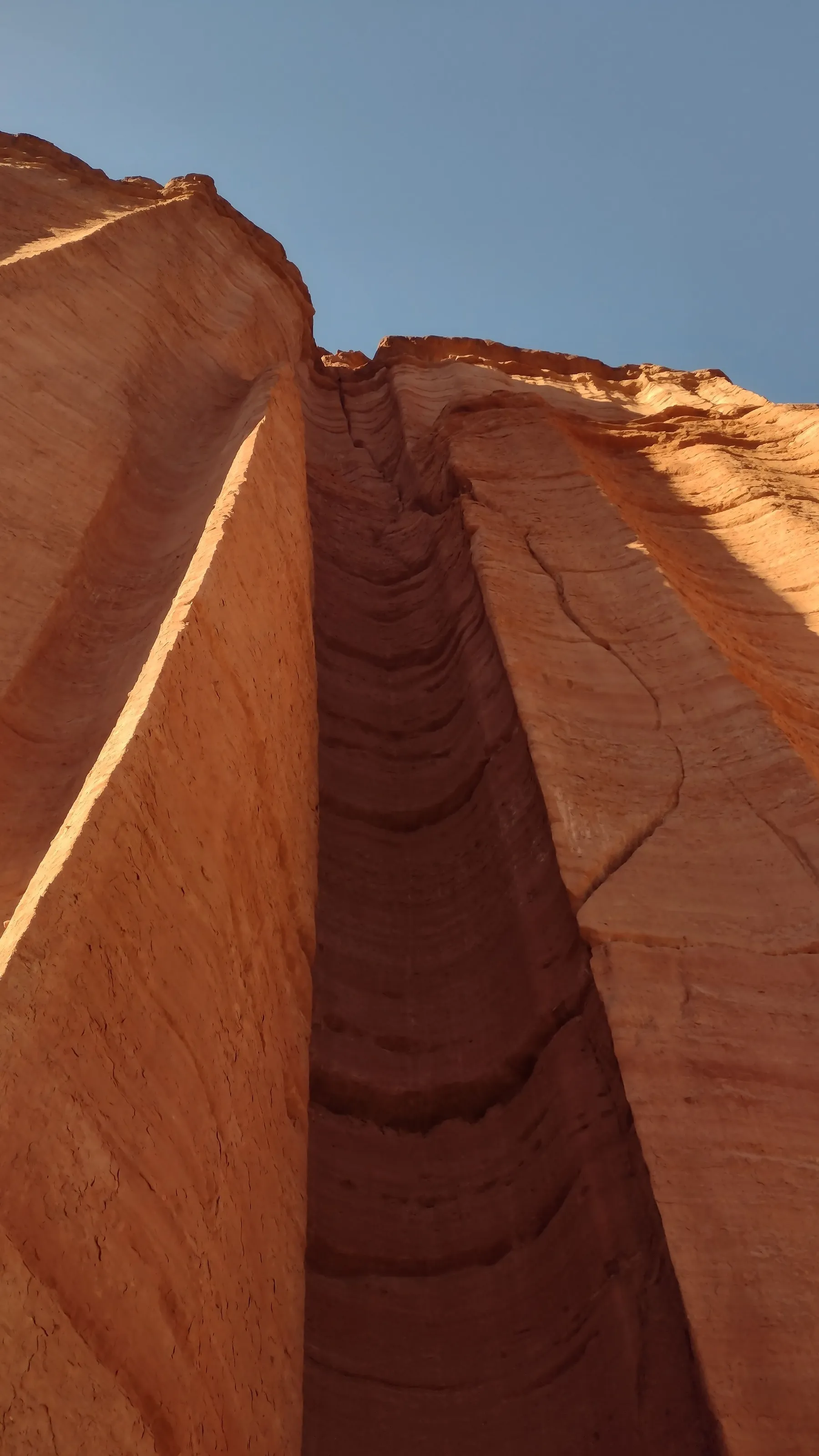 A low view of towering red sandstone cliffs in Talampaya