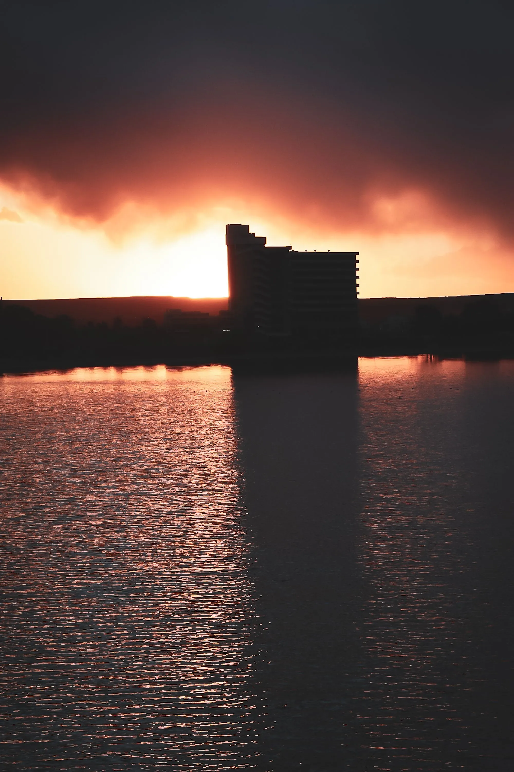 Silhouetted waterfront buildings against golden evening light at Puerto Madryn