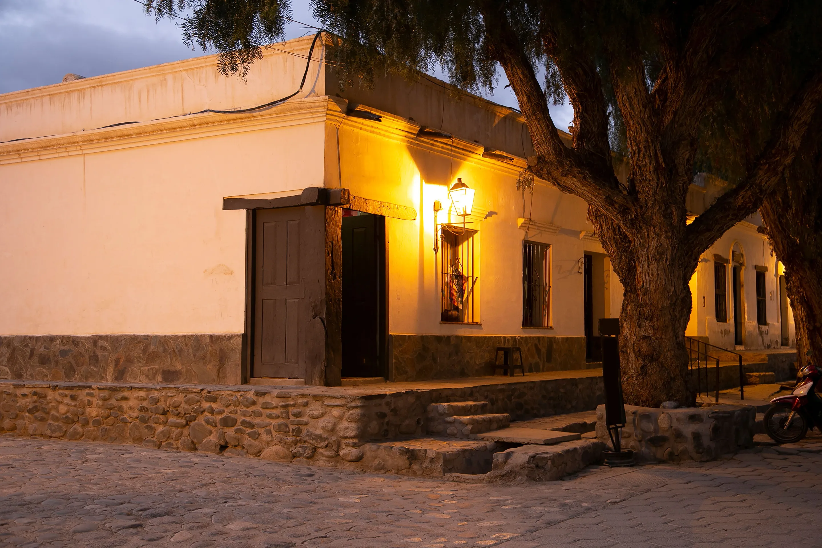 A warmly lit street corner in Cachi at twilight