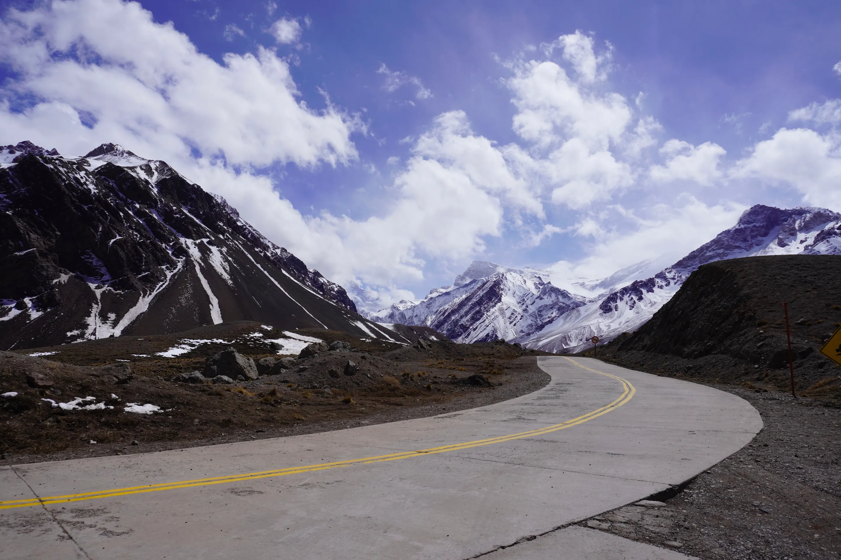 A road winding between snow-capped mountains in Argentina.