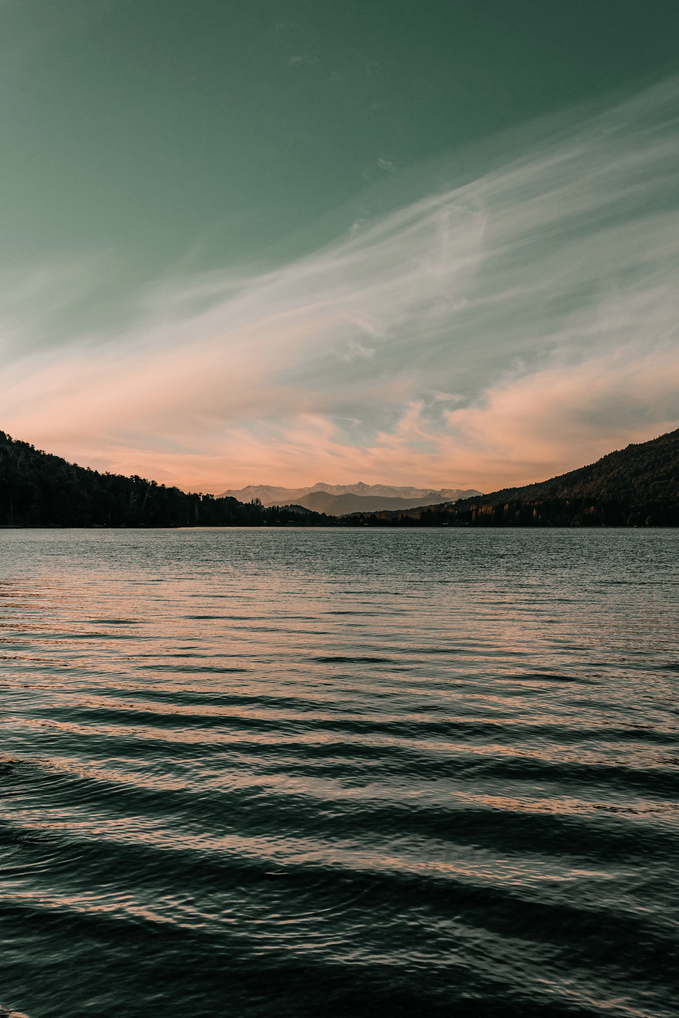 Mountain silhouettes and evening light reflected on a lake near Bariloche