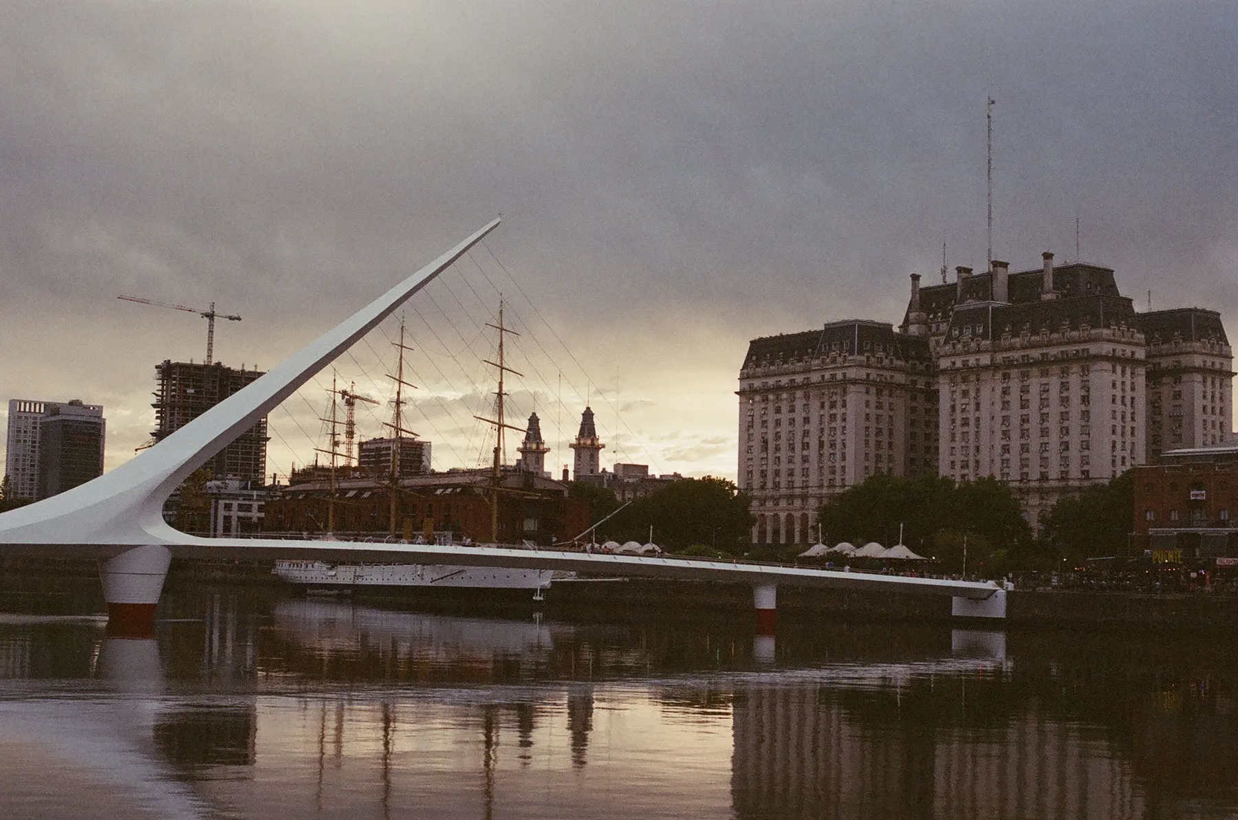 Puente de la Mujer and the city skyline across the docks at dusk