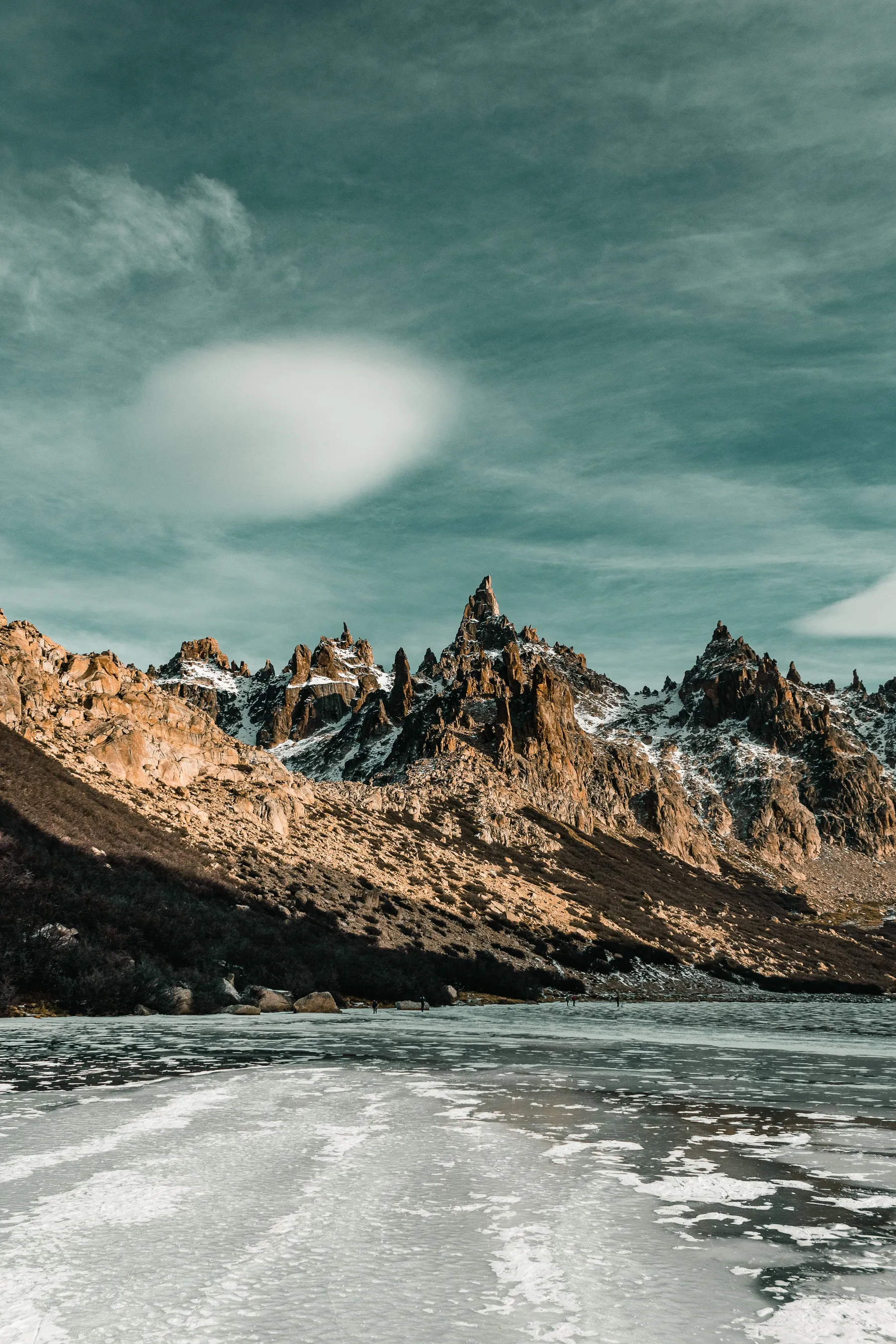 Snowy rock peaks rising above a frozen mountain lake in Bariloche.