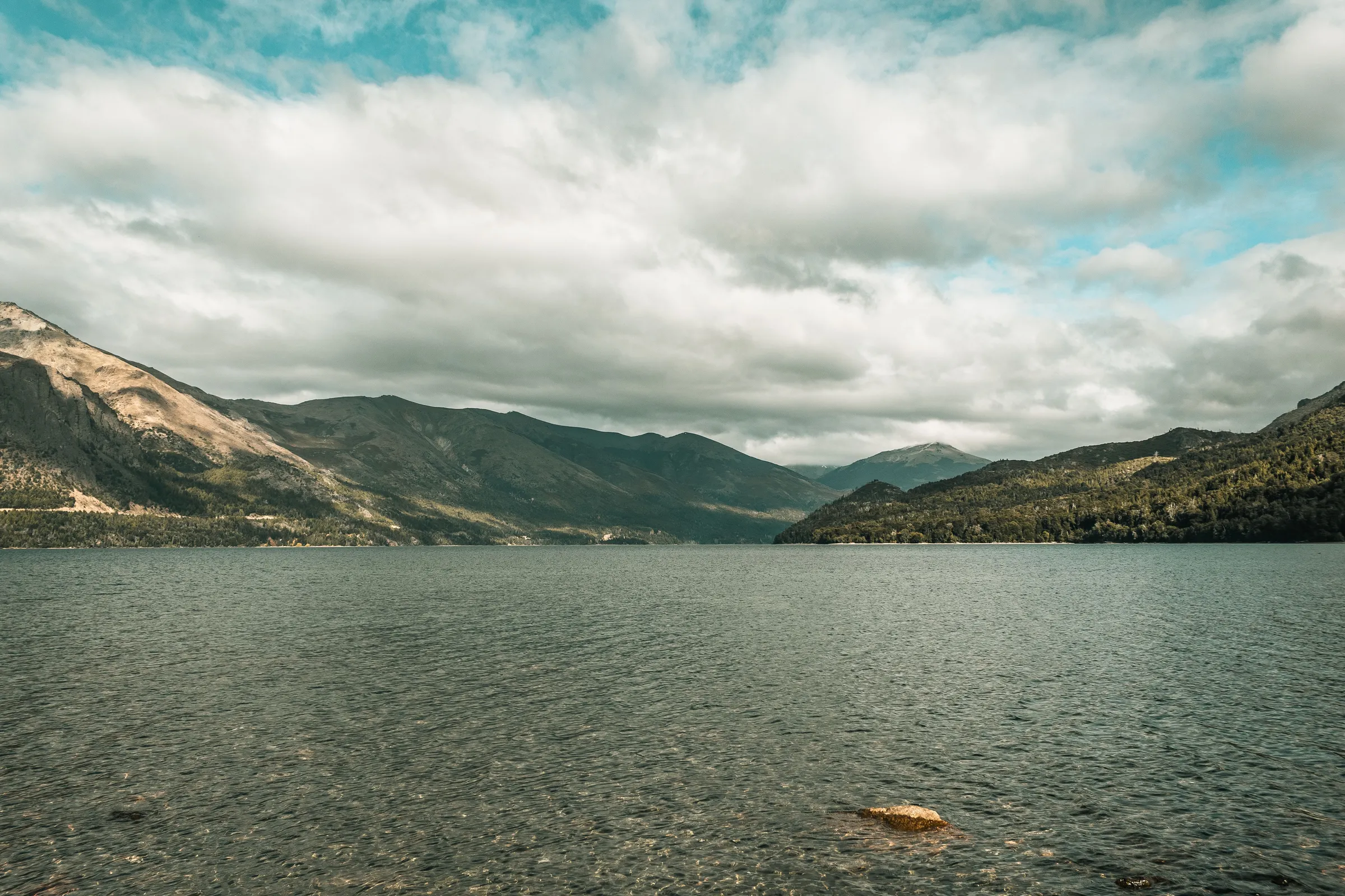 Andean mountain walls and lake water beneath cloud in Nahuel Huapi
