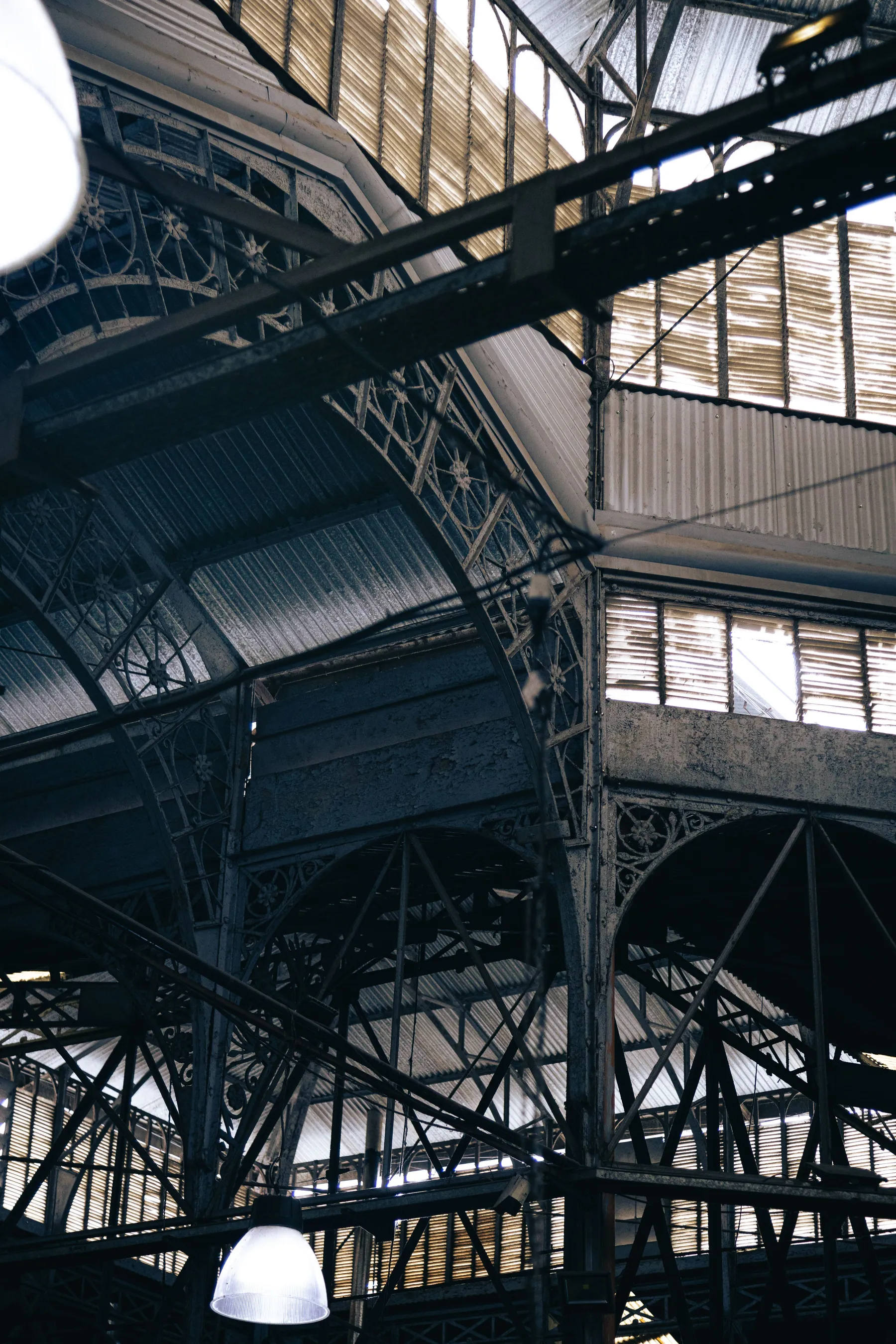 Light falling across the metal roof structure of a Buenos Aires market.