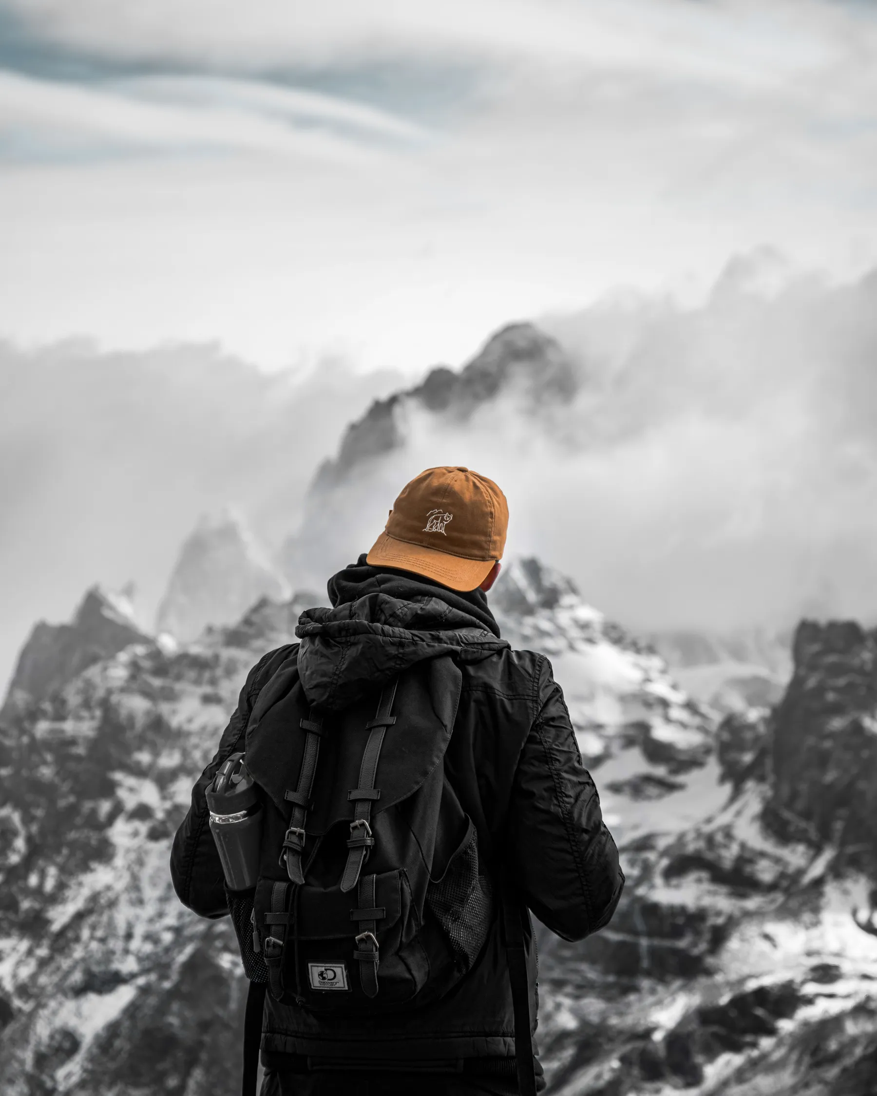 A hiker beneath cloud-covered mountains near El Chaltén.