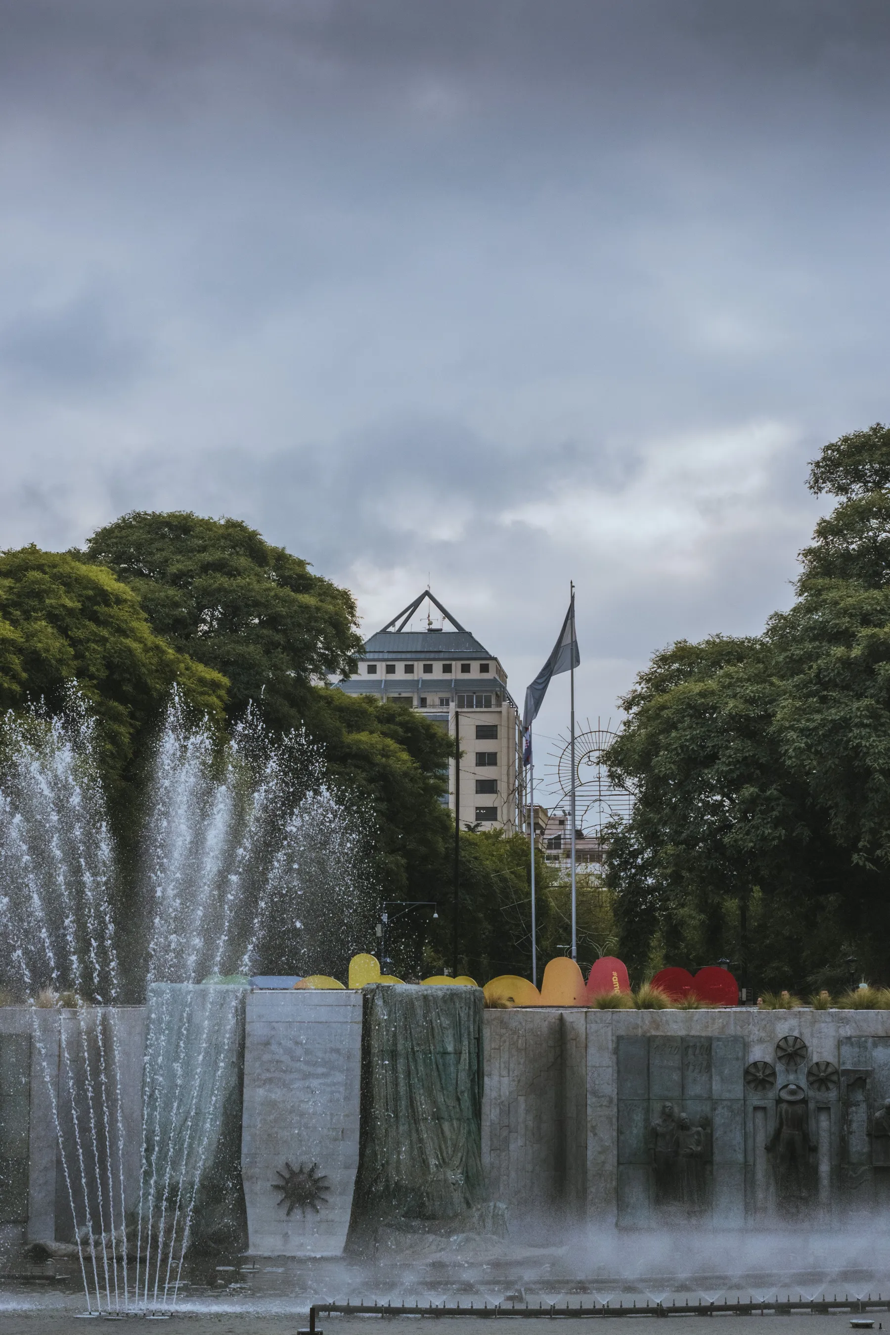 A fountain and monument framed by greenery in Mendoza