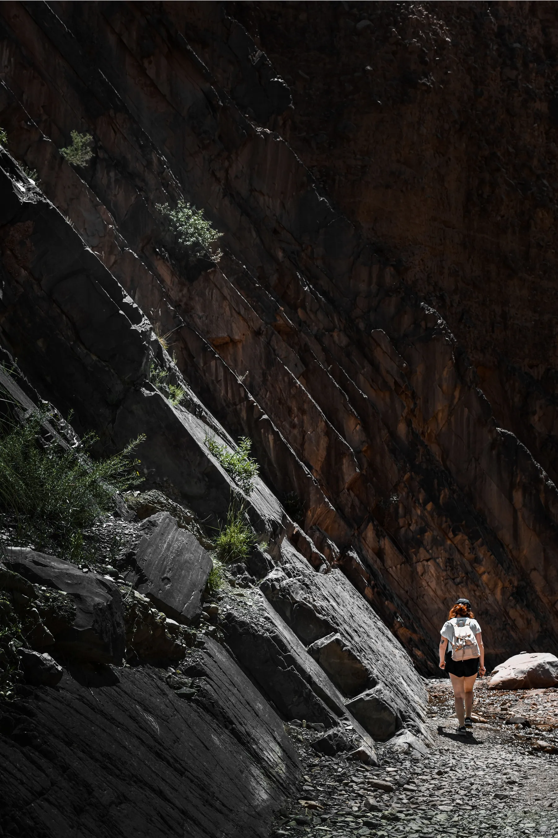 A walker beneath rugged rock walls near Tilcara