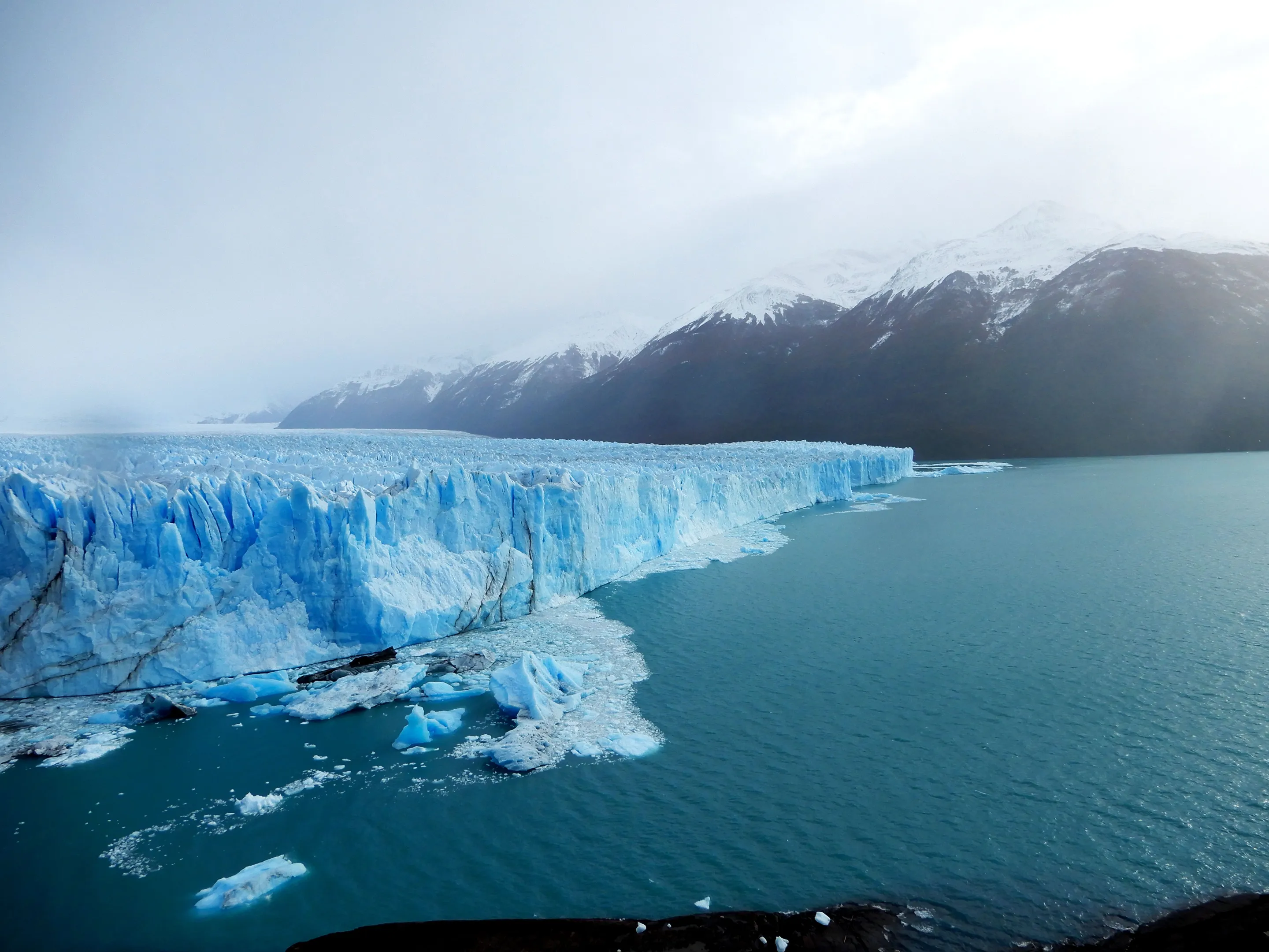 The broad ice front of Perito Moreno Glacier beneath Patagonian cloud.