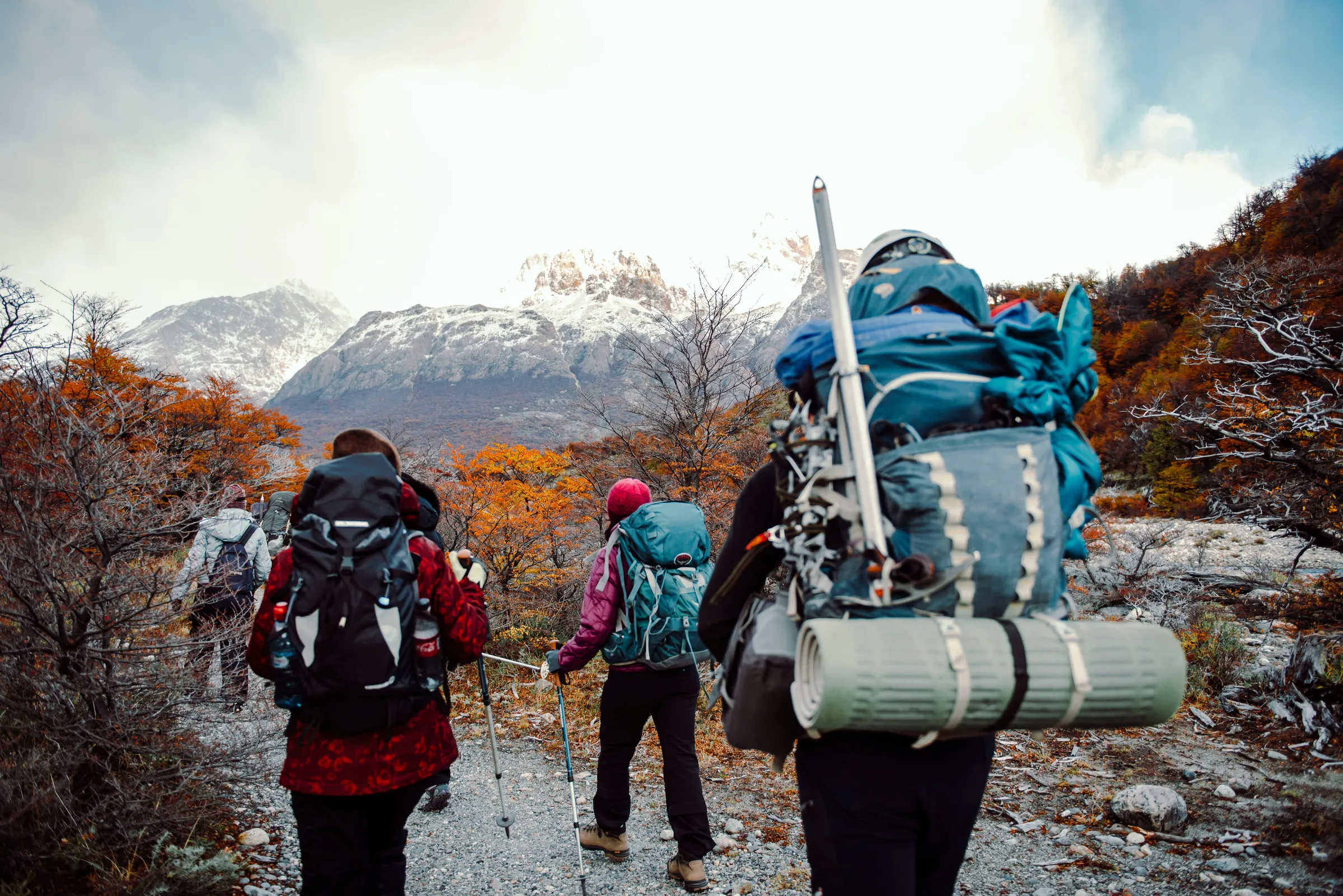 Walkers with backpacks following an autumn mountain trail near El Chaltén
