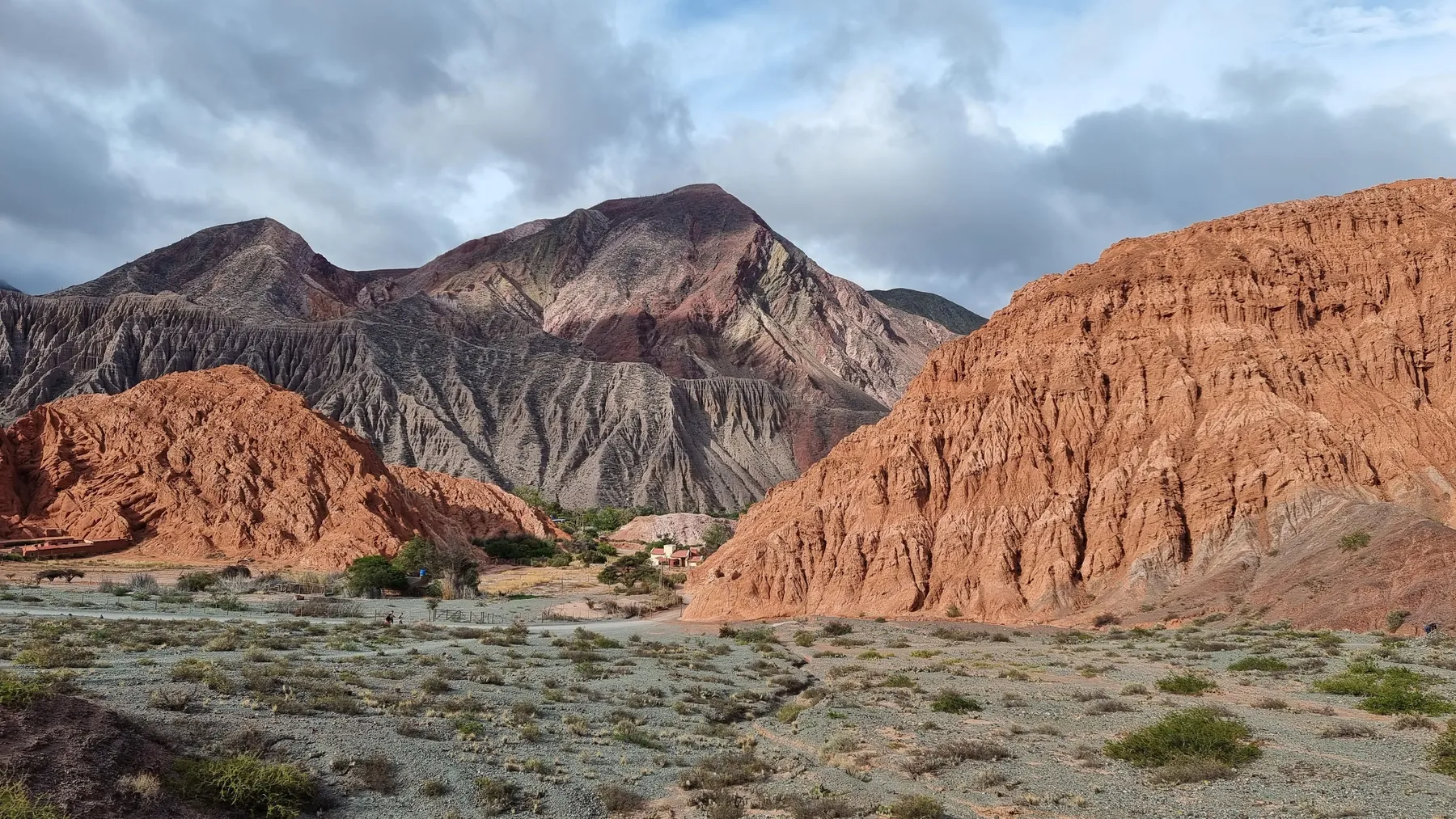 Weathered hills and a dry valley under dramatic skies near Purmamarca