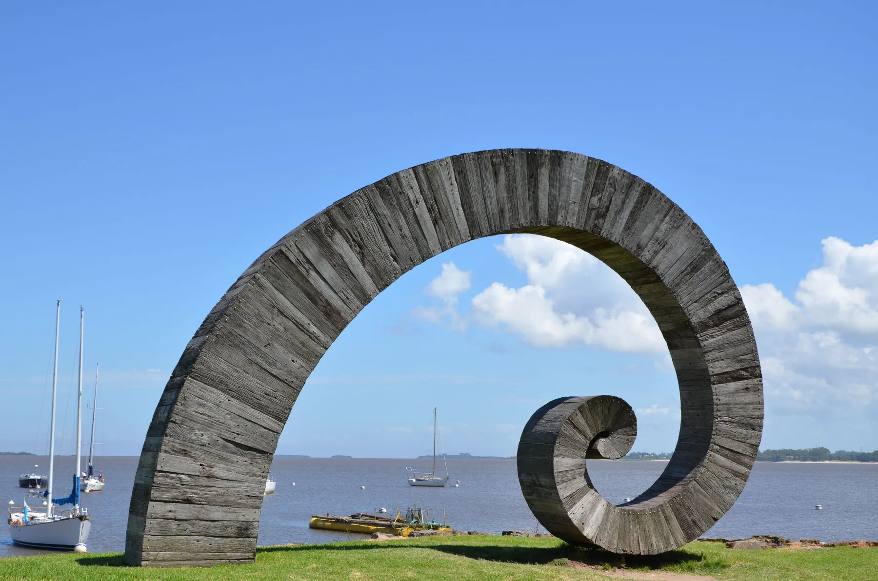 A wooden sculpture beside the Río de la Plata waterfront at Colonia del Sacramento