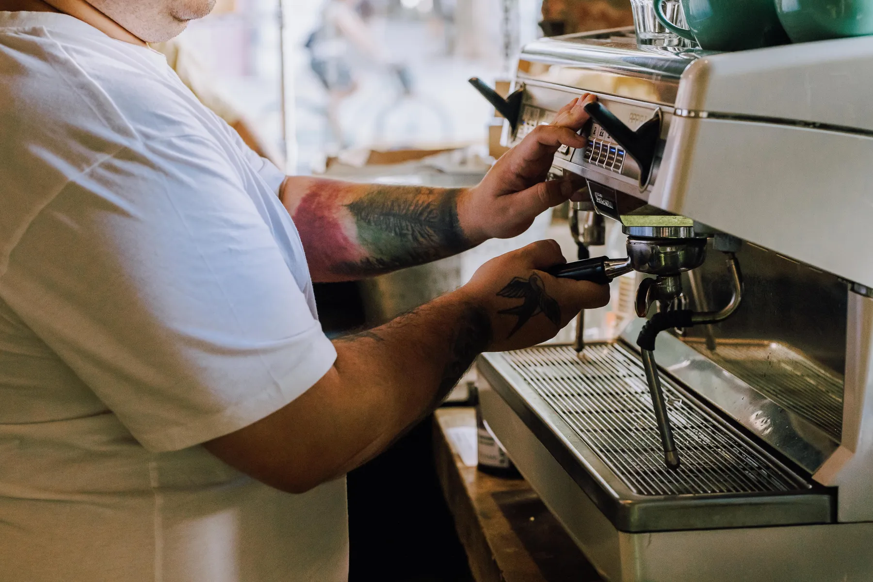A barista preparing espresso in warm café light