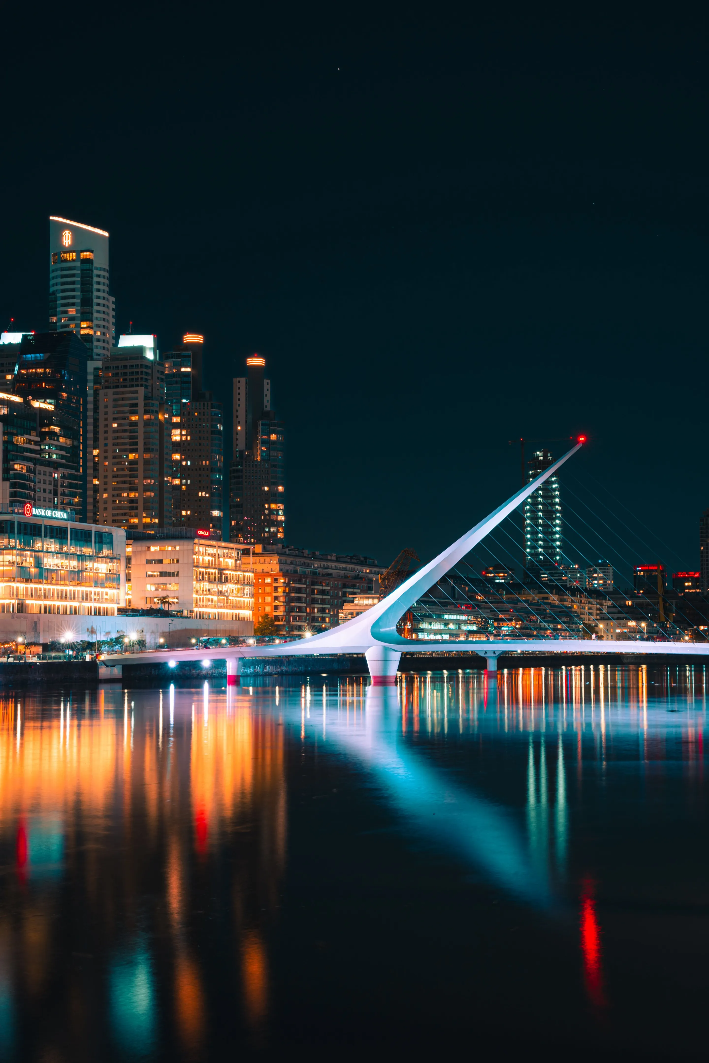 Illuminated Puente de la Mujer reflected in the docks at night