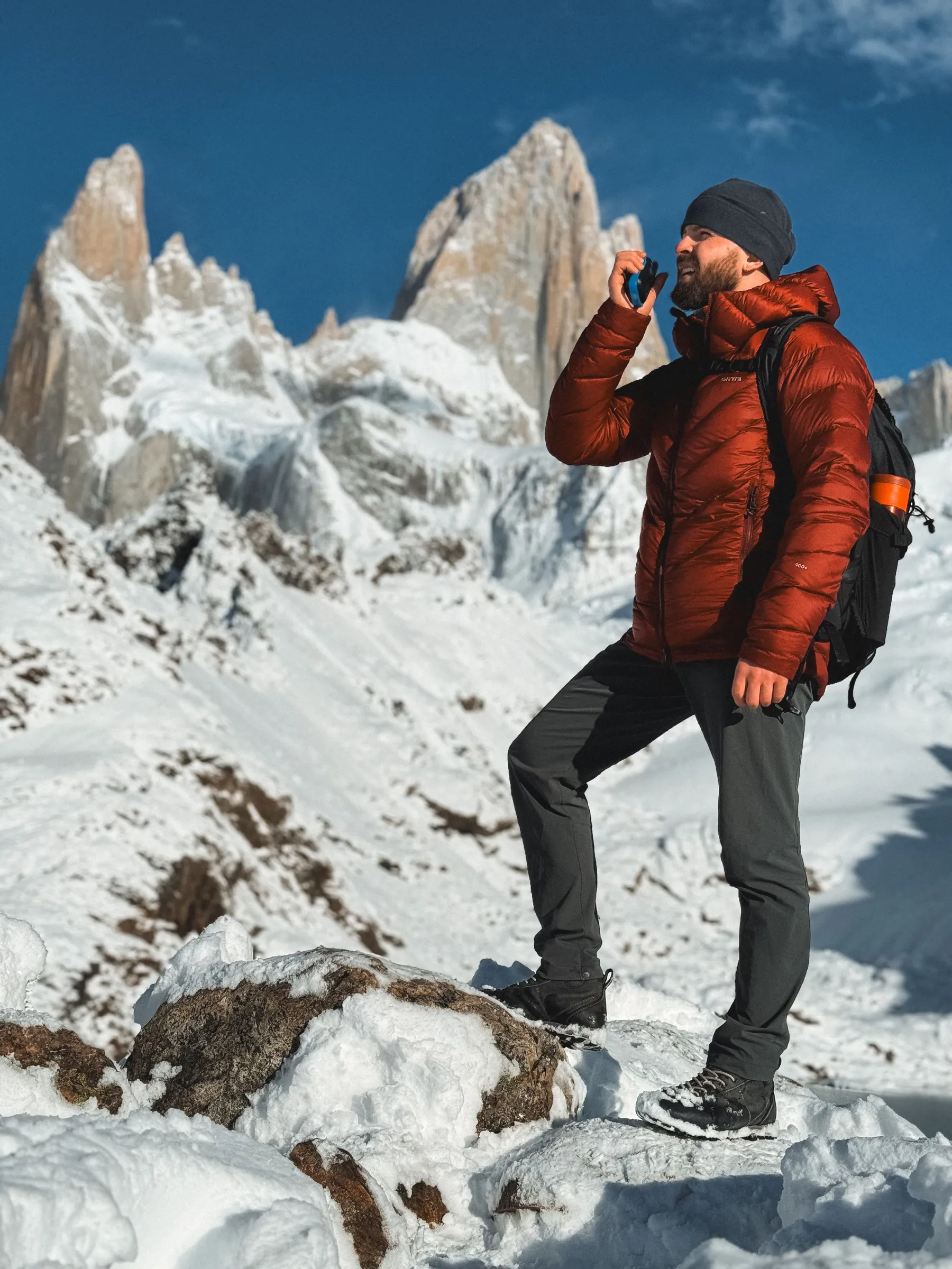 A hiker and snowy mountain terrain beneath Fitz Roy.