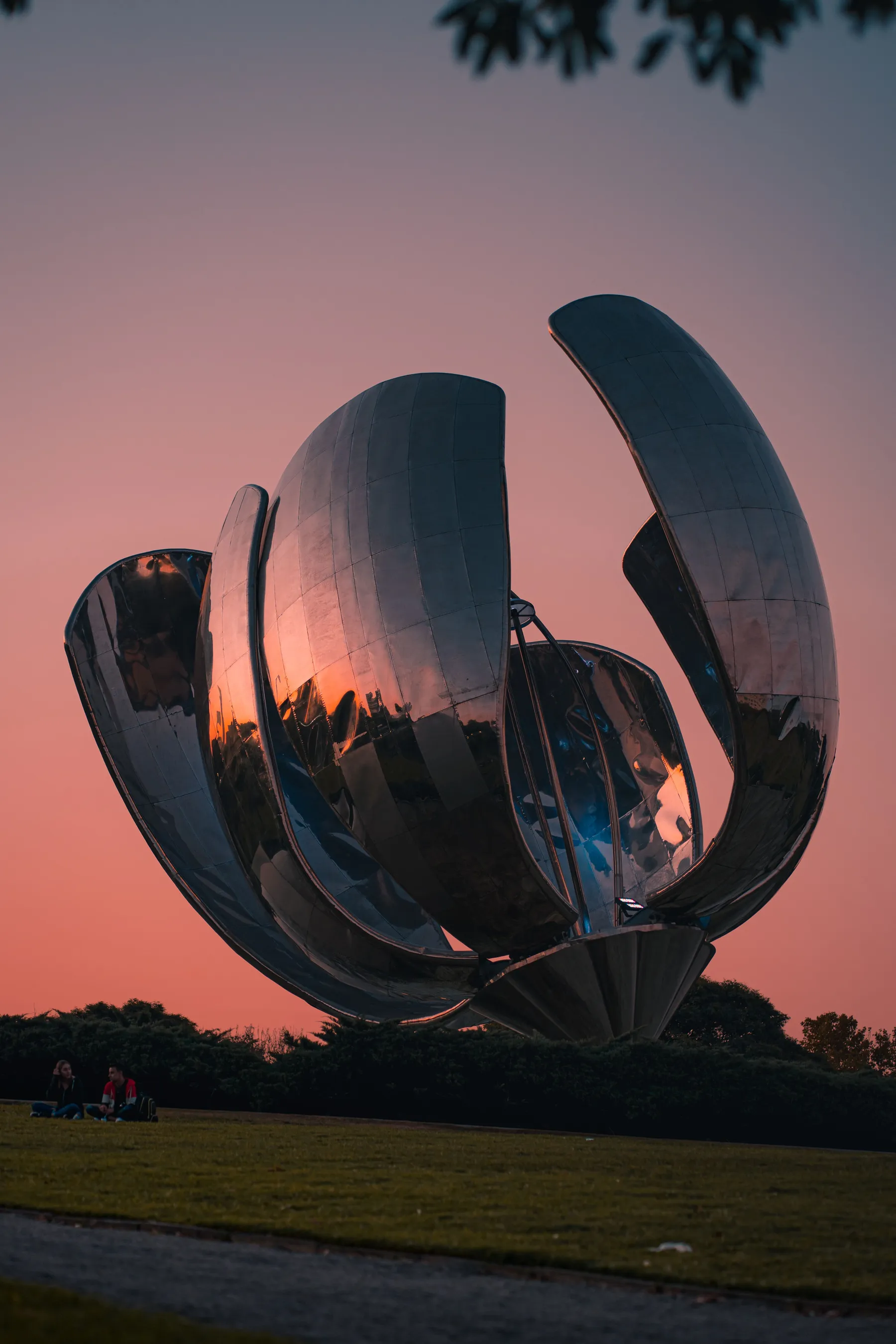 Reflective steel petals of Floralis Genérica beneath an evening sky