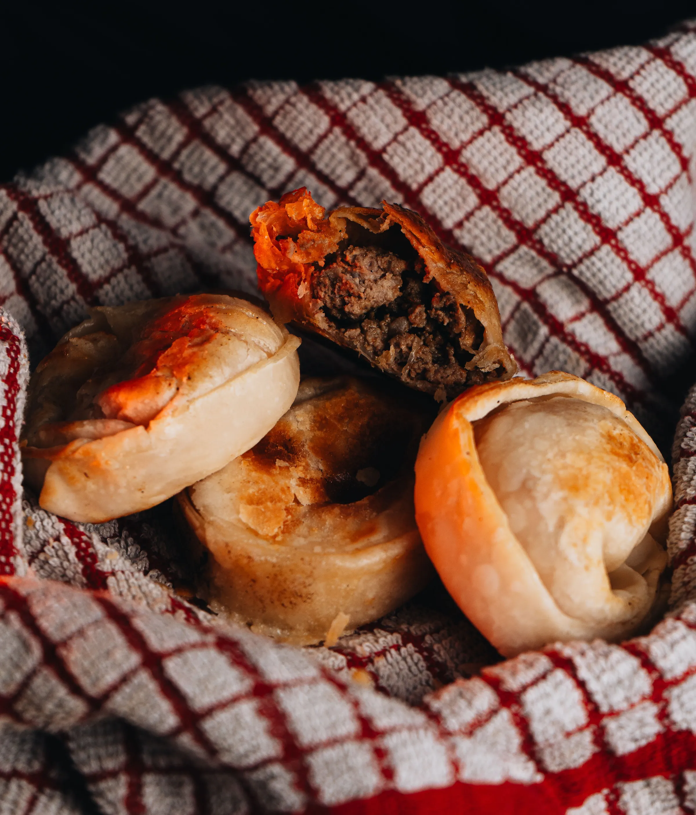 A close-up of Argentine empanadas on a checked cloth in Mendoza.