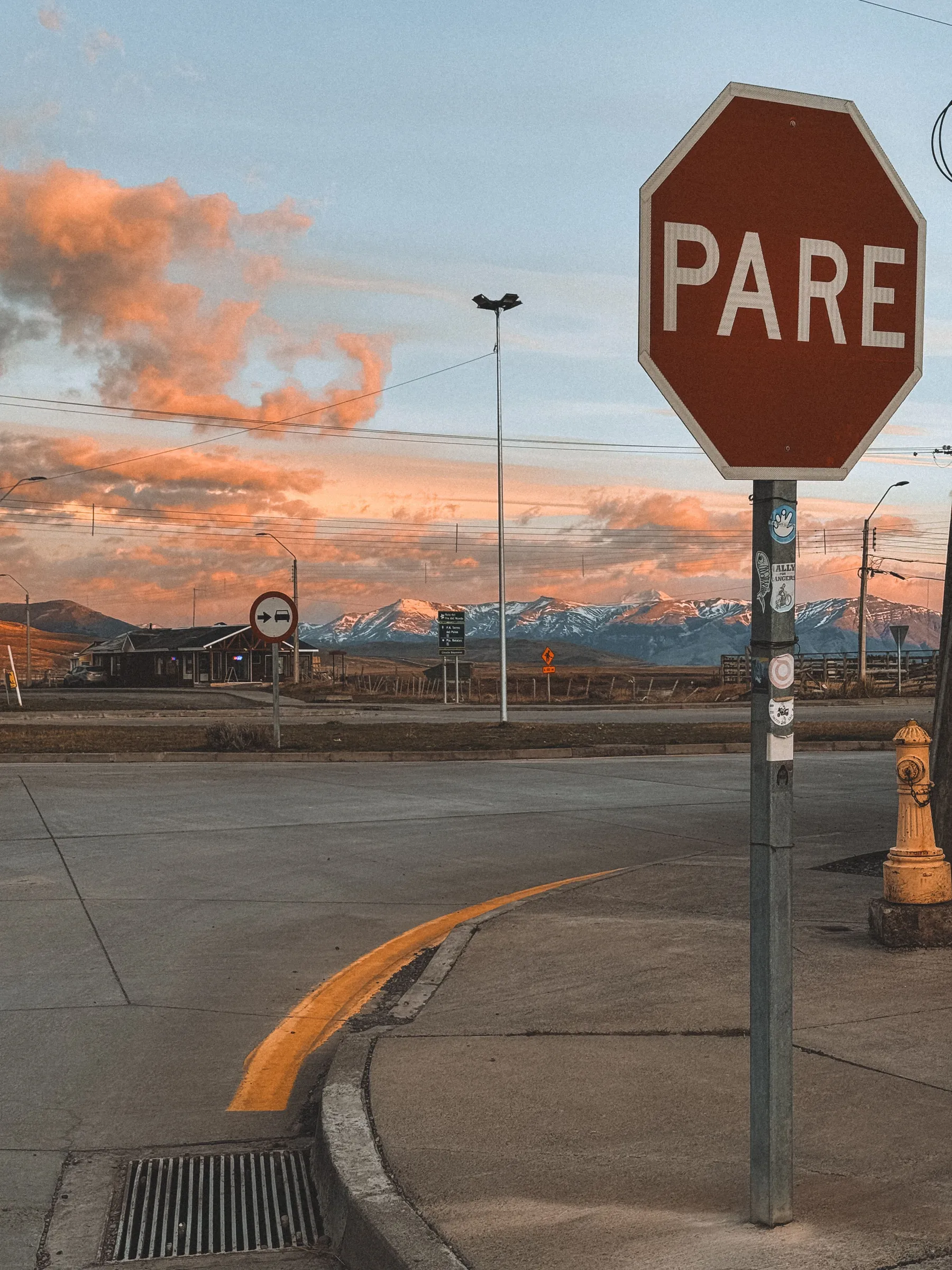 A stop sign beside a street in El Calafate at sunset