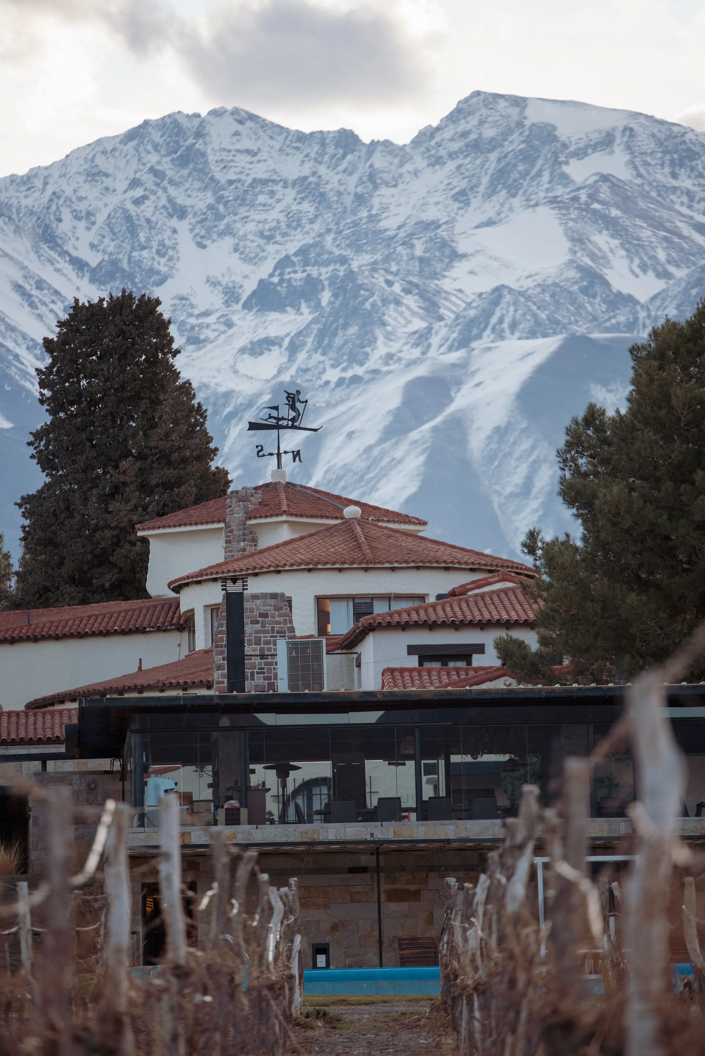 A house, vineyard and mountain backdrop in Mendoza in winter.