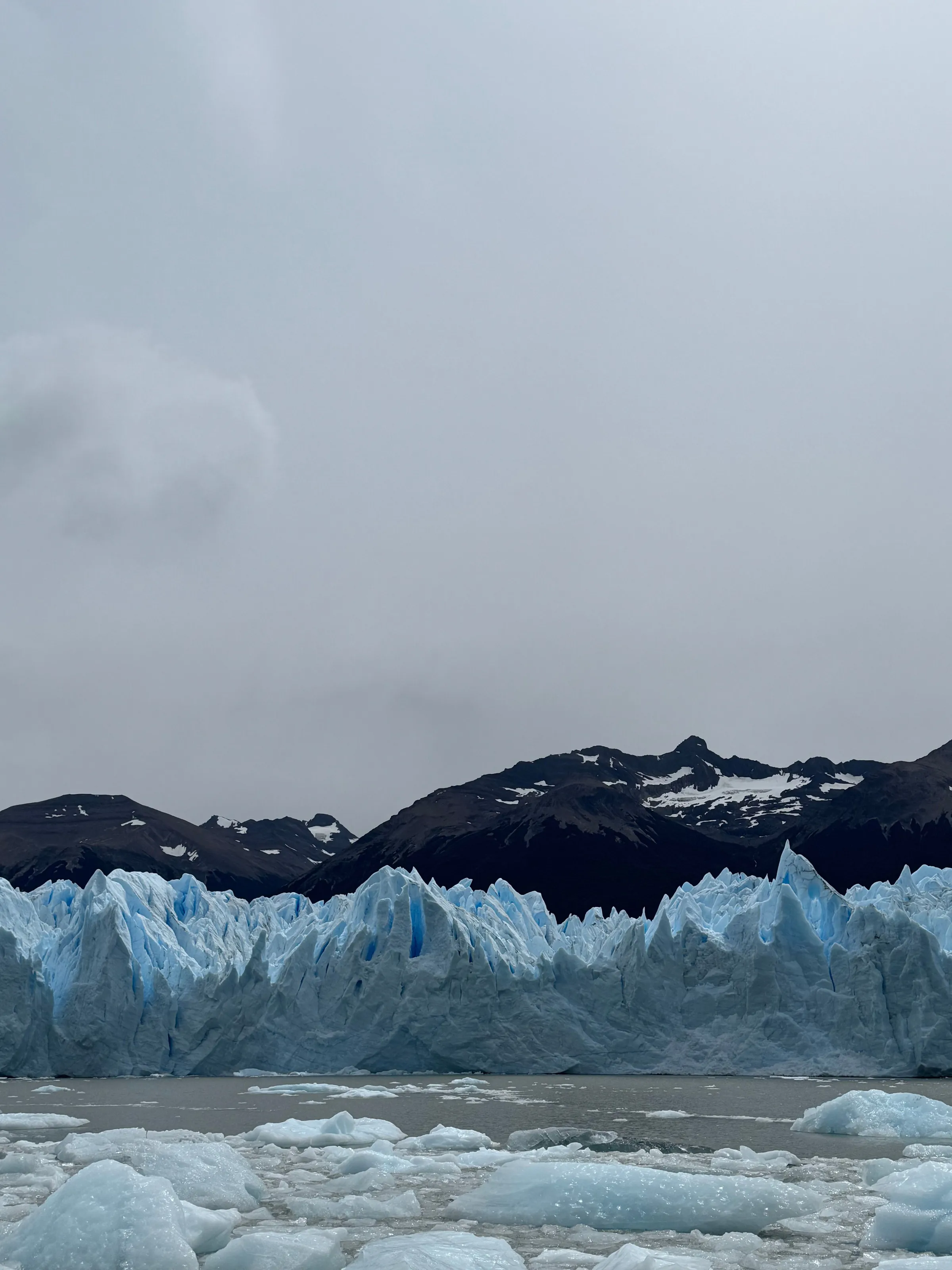 Blue glacier ice beneath a dramatic clouded Patagonian sky