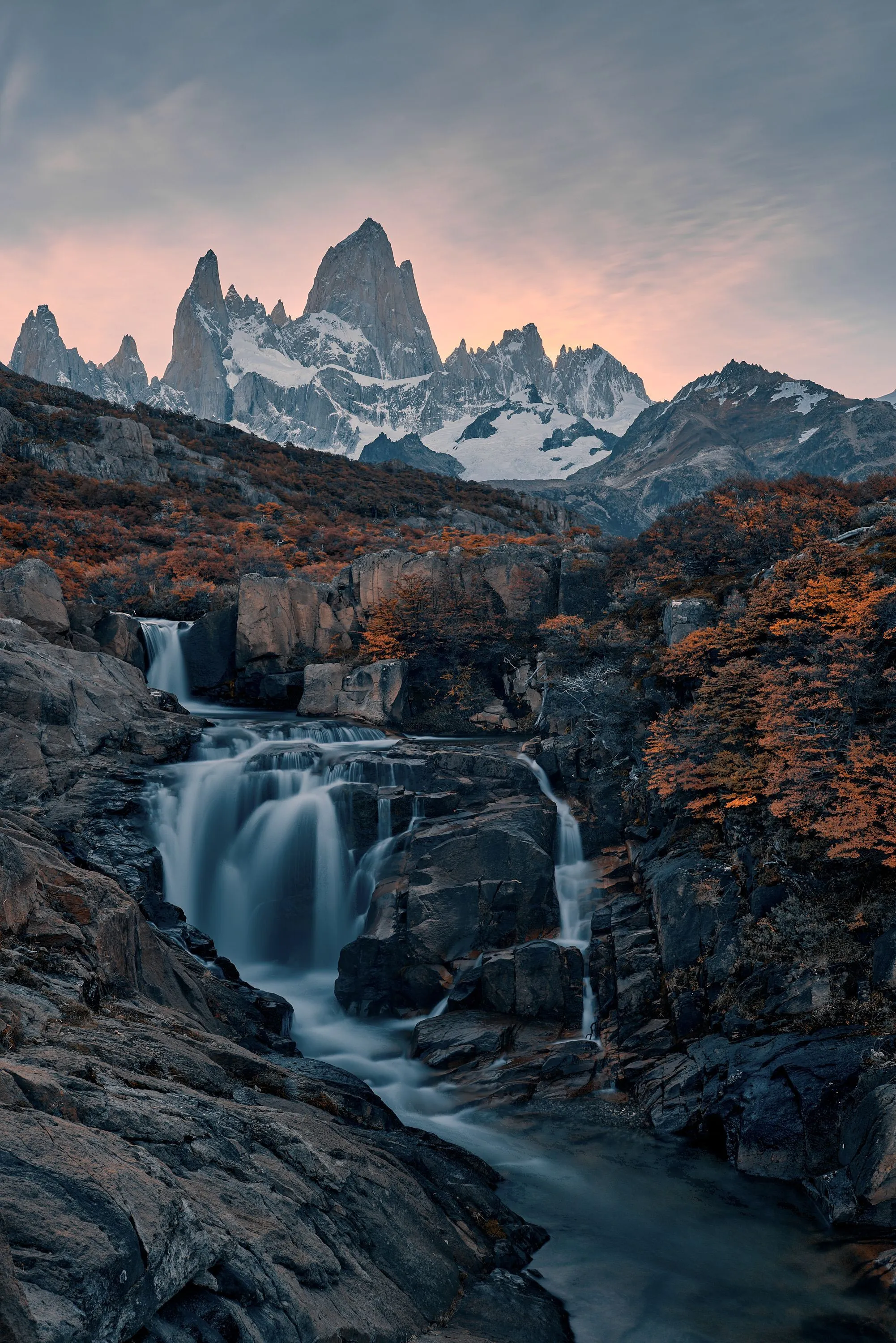 A mountain stream flowing over rocks beneath the Fitz Roy skyline