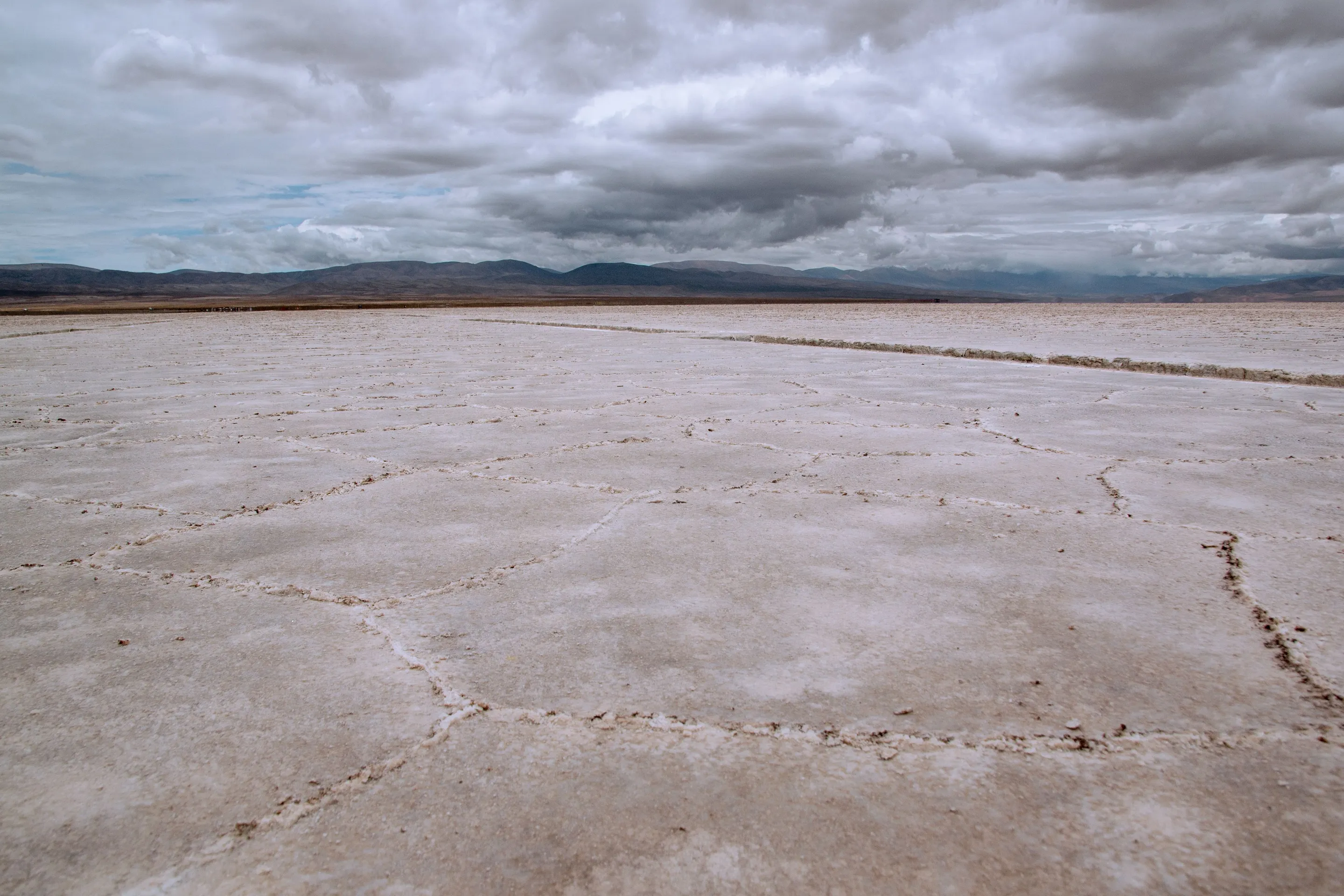 White salt crust stretching beneath dramatic clouds at Salinas Grandes