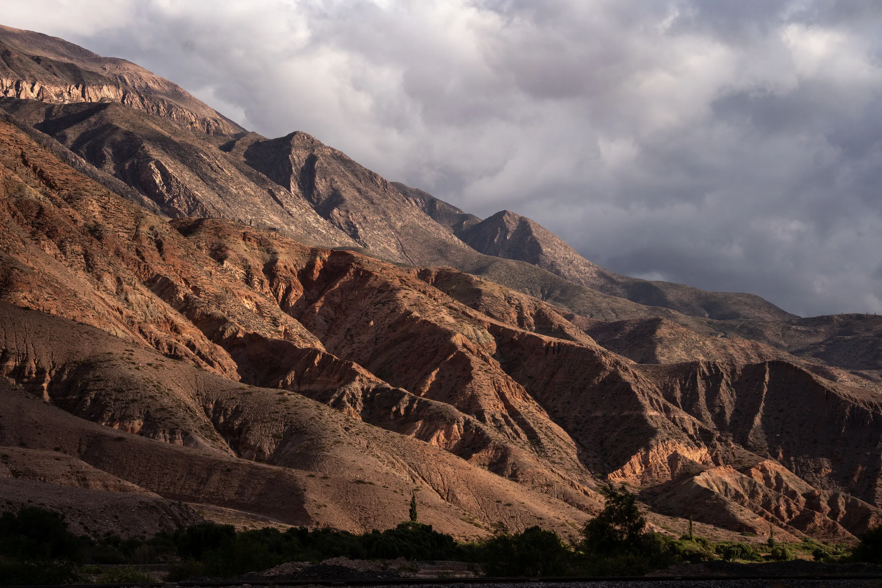 Folded mountain ridges near Maimará beneath dramatic cloud