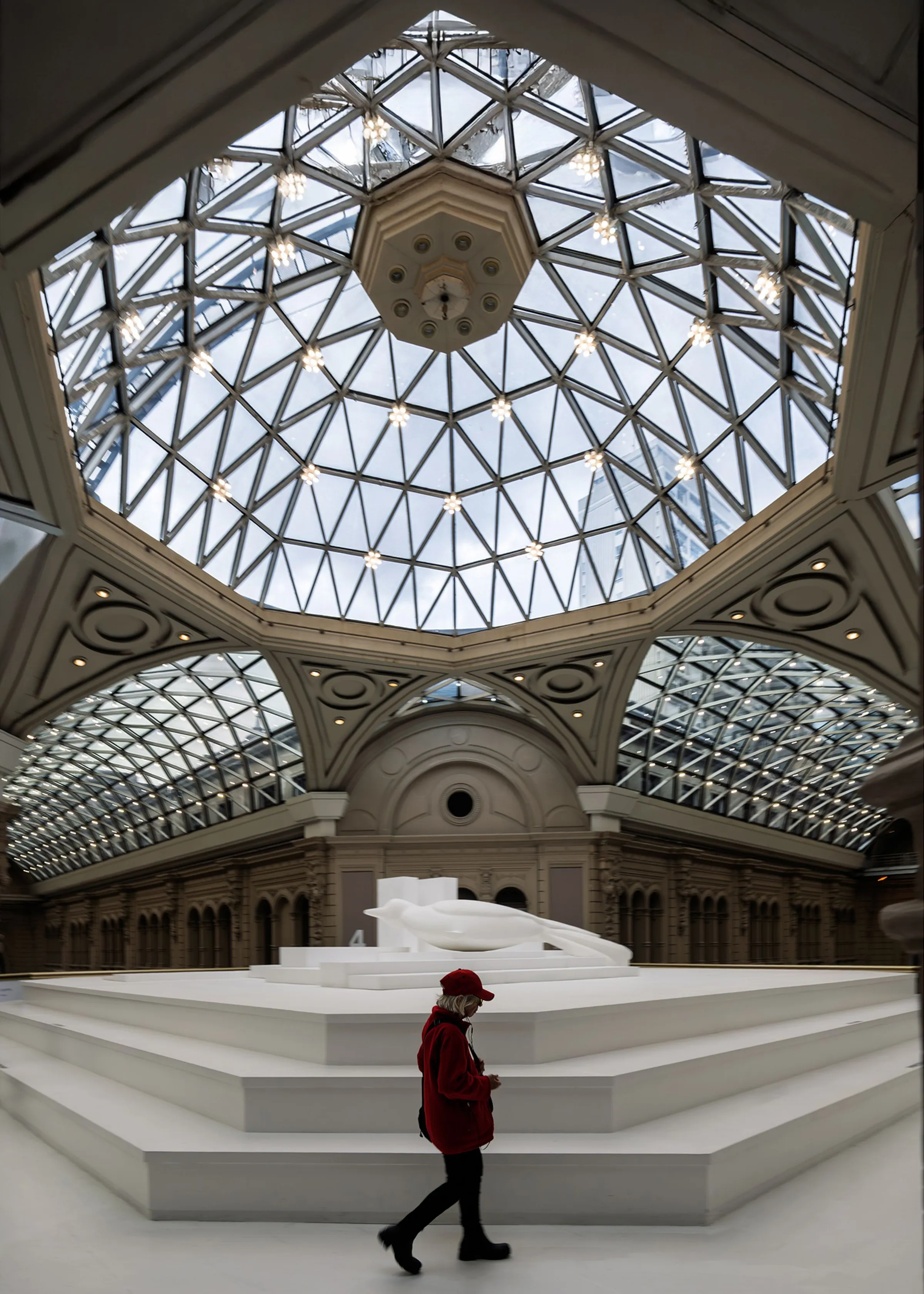 A geometric atrium and a visitor in red in Buenos Aires.