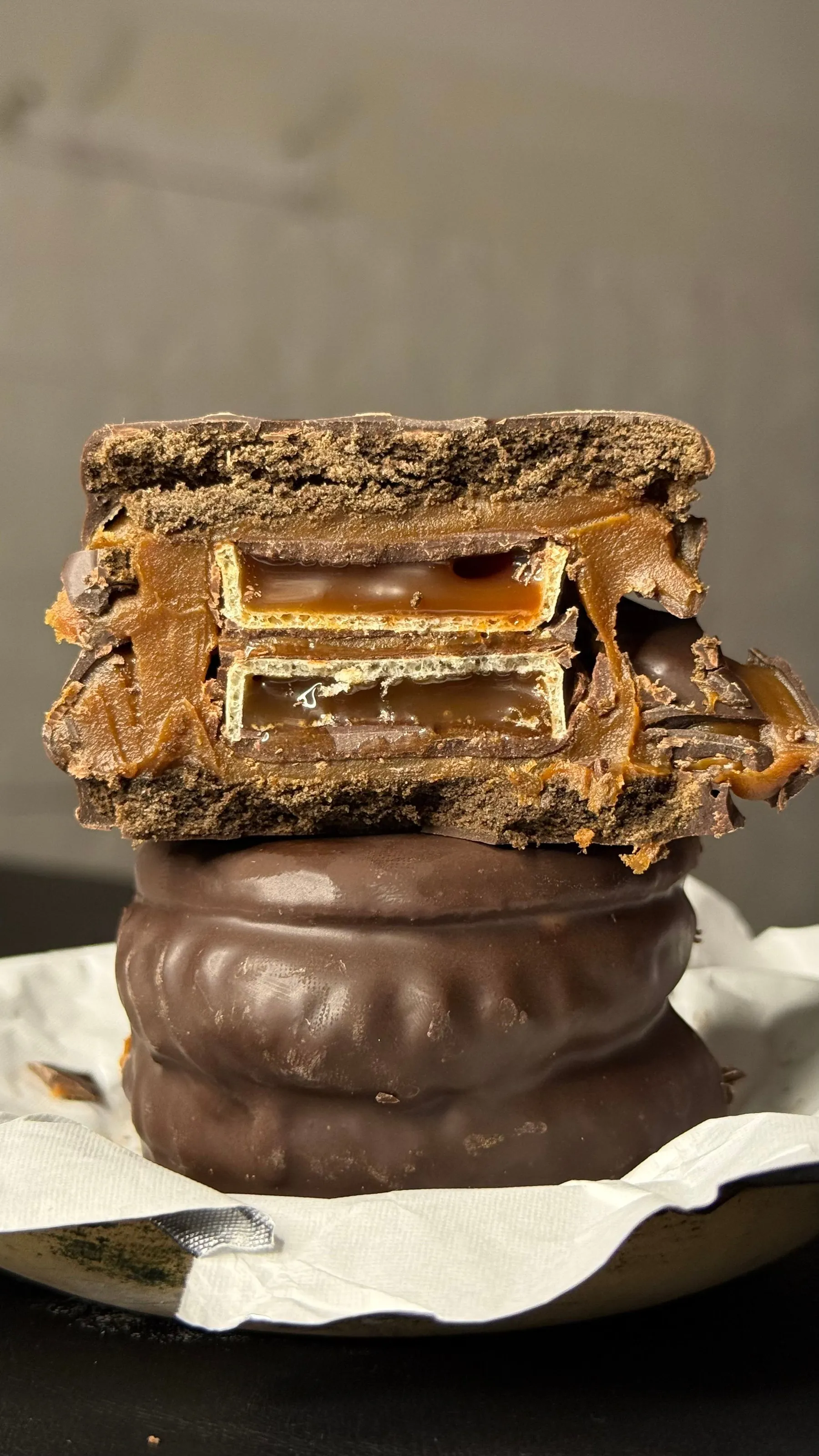 A close-up of an alfajor with a thick dulce de leche filling.