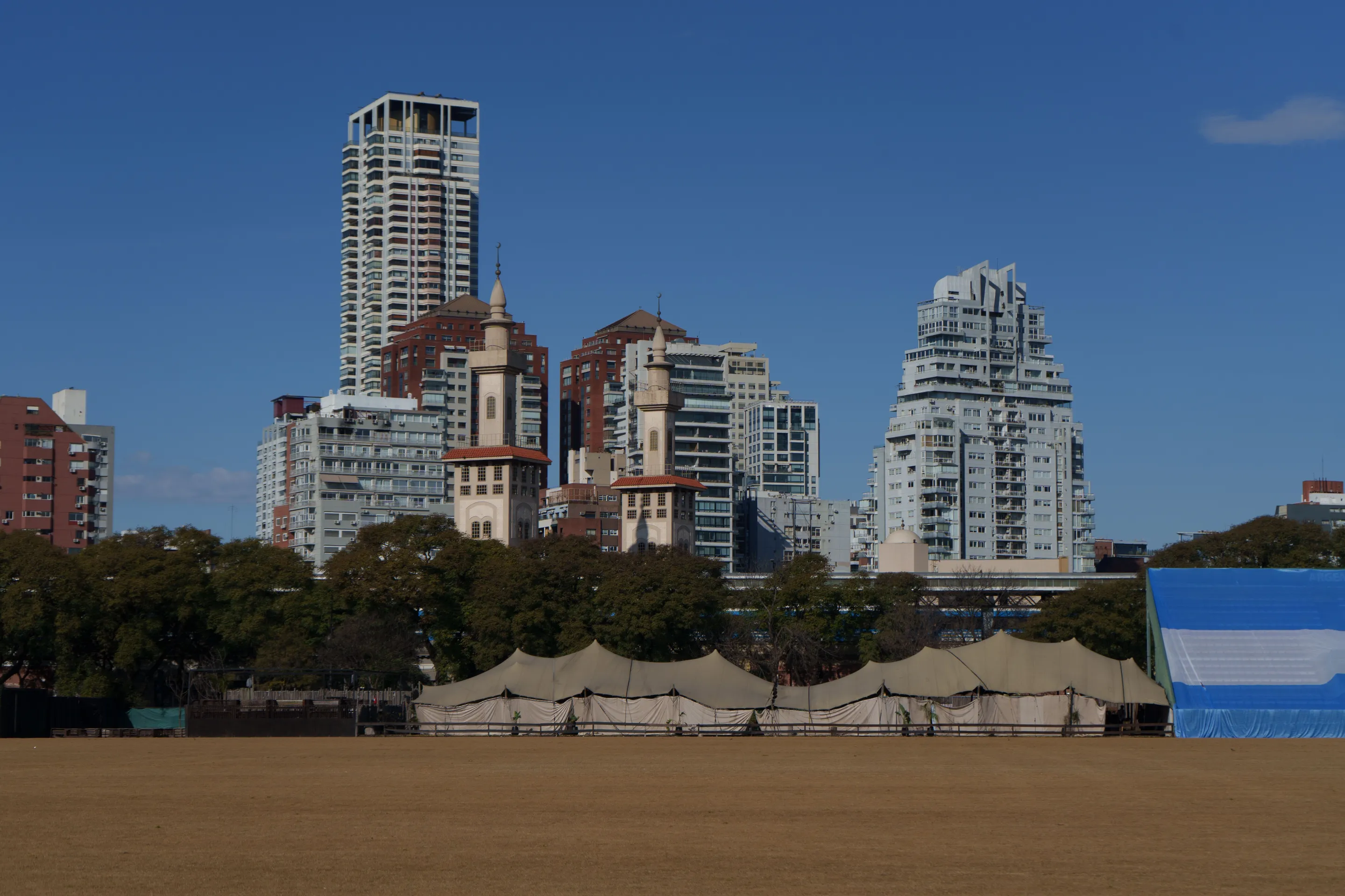 Modern and older buildings above an open field in Buenos Aires
