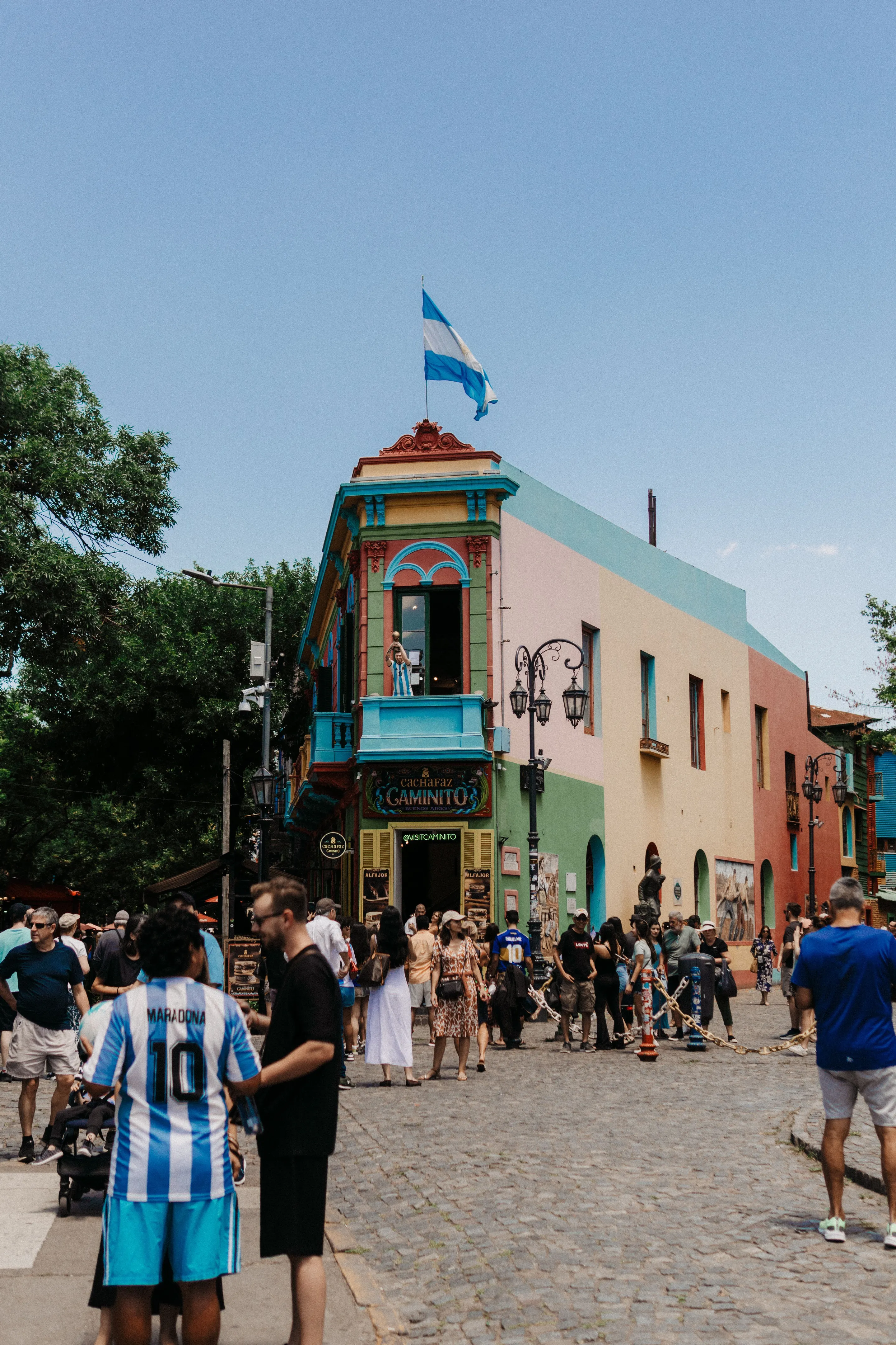 Visitors walking among the vividly painted buildings of Caminito