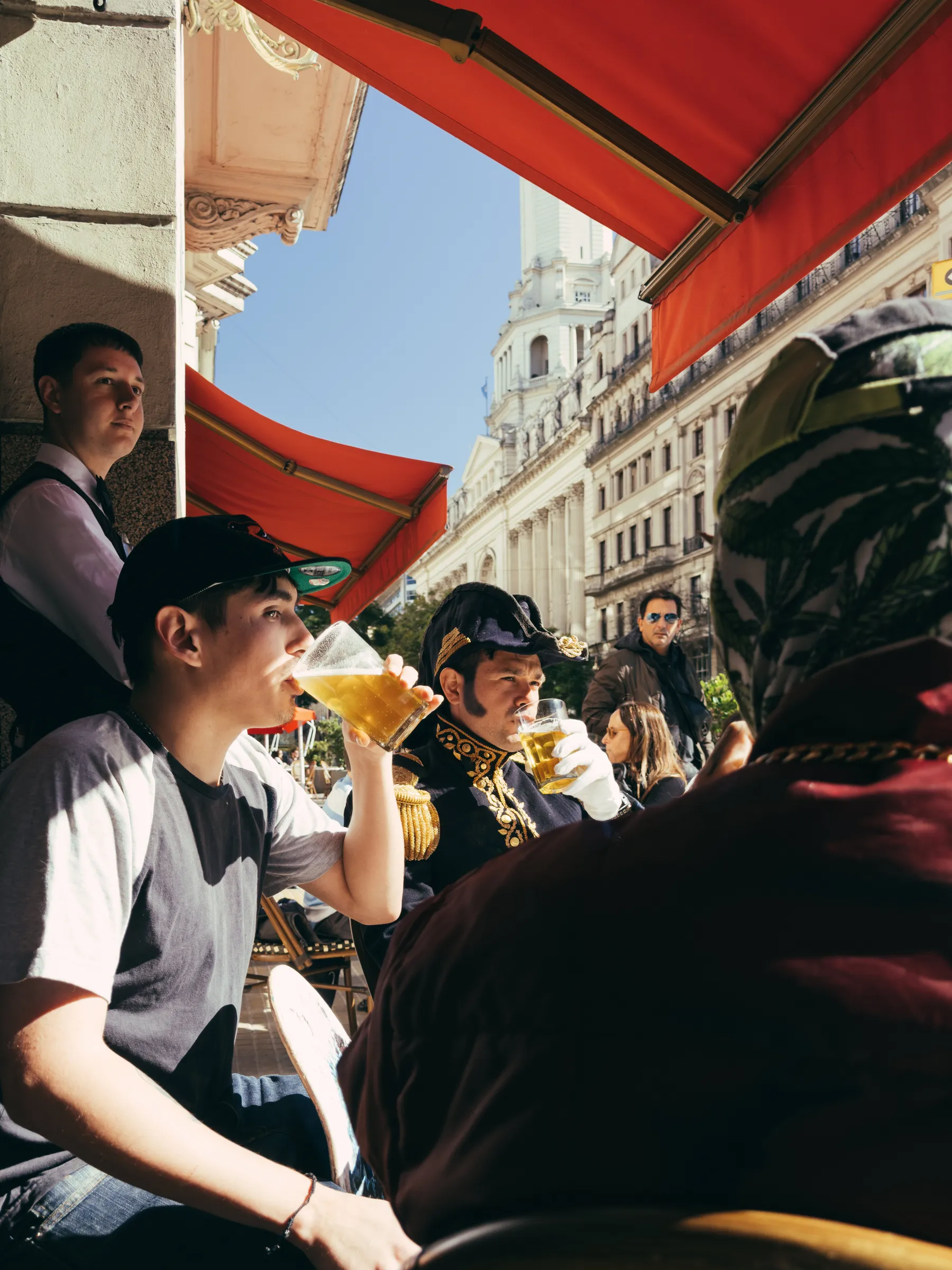 Café tables and everyday conversation on a Buenos Aires street.