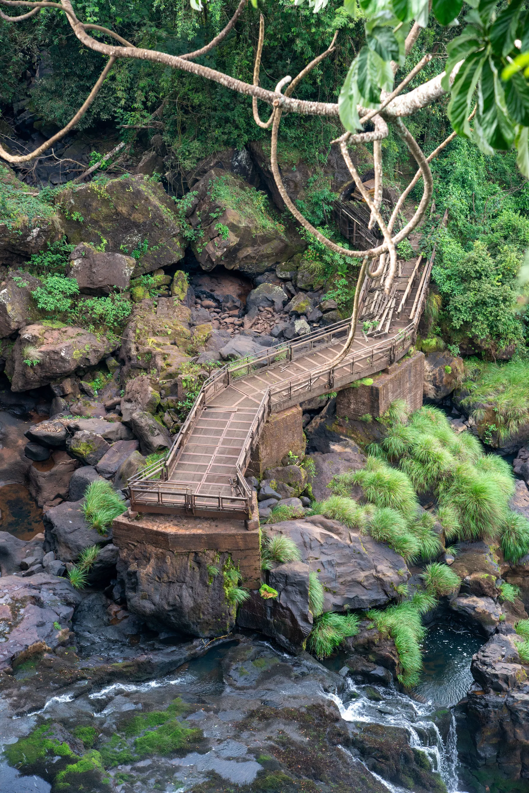 Steps and a raised path winding between rocks and water at Iguazú