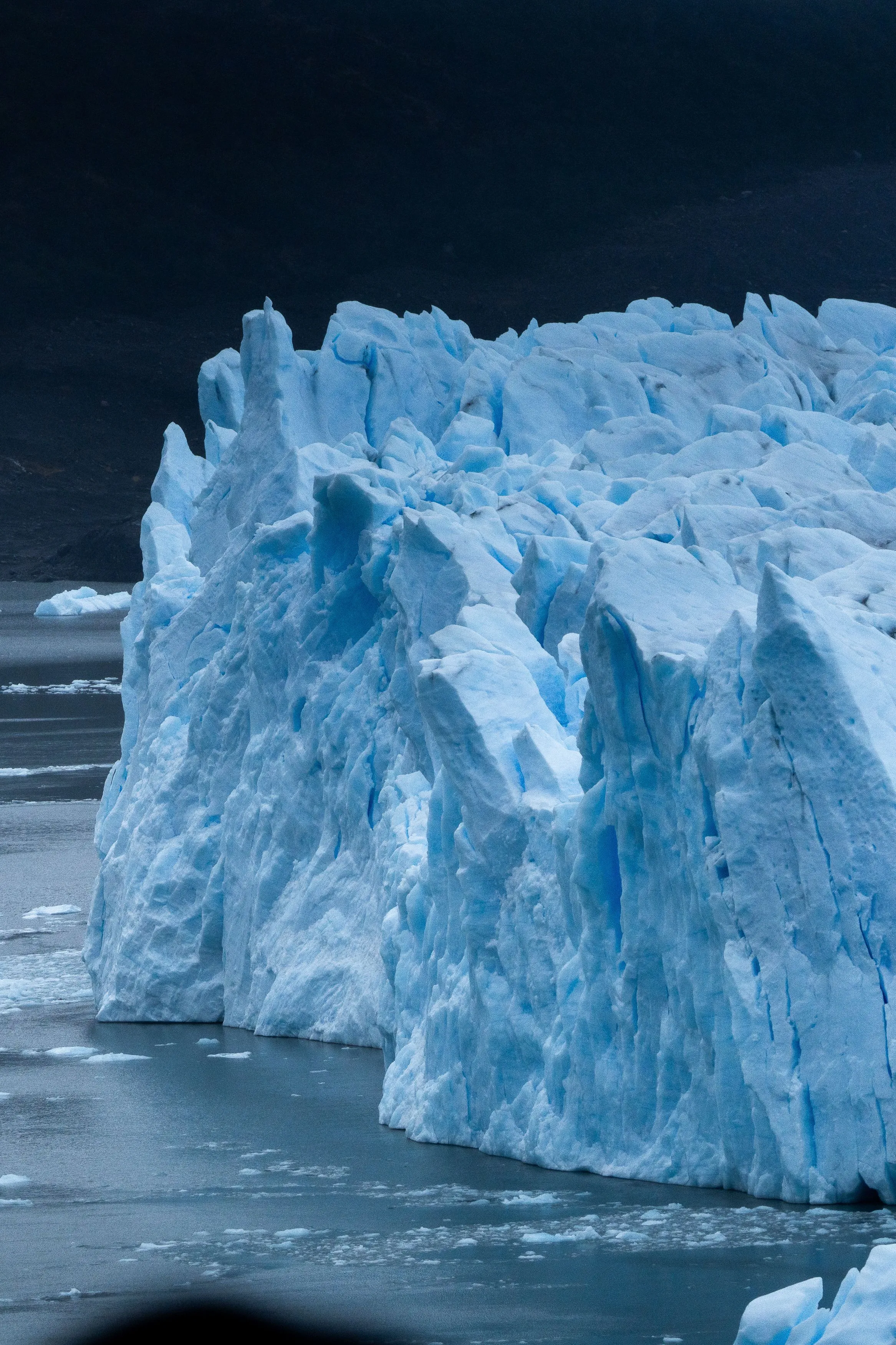 A towering blue glacier front beside the water