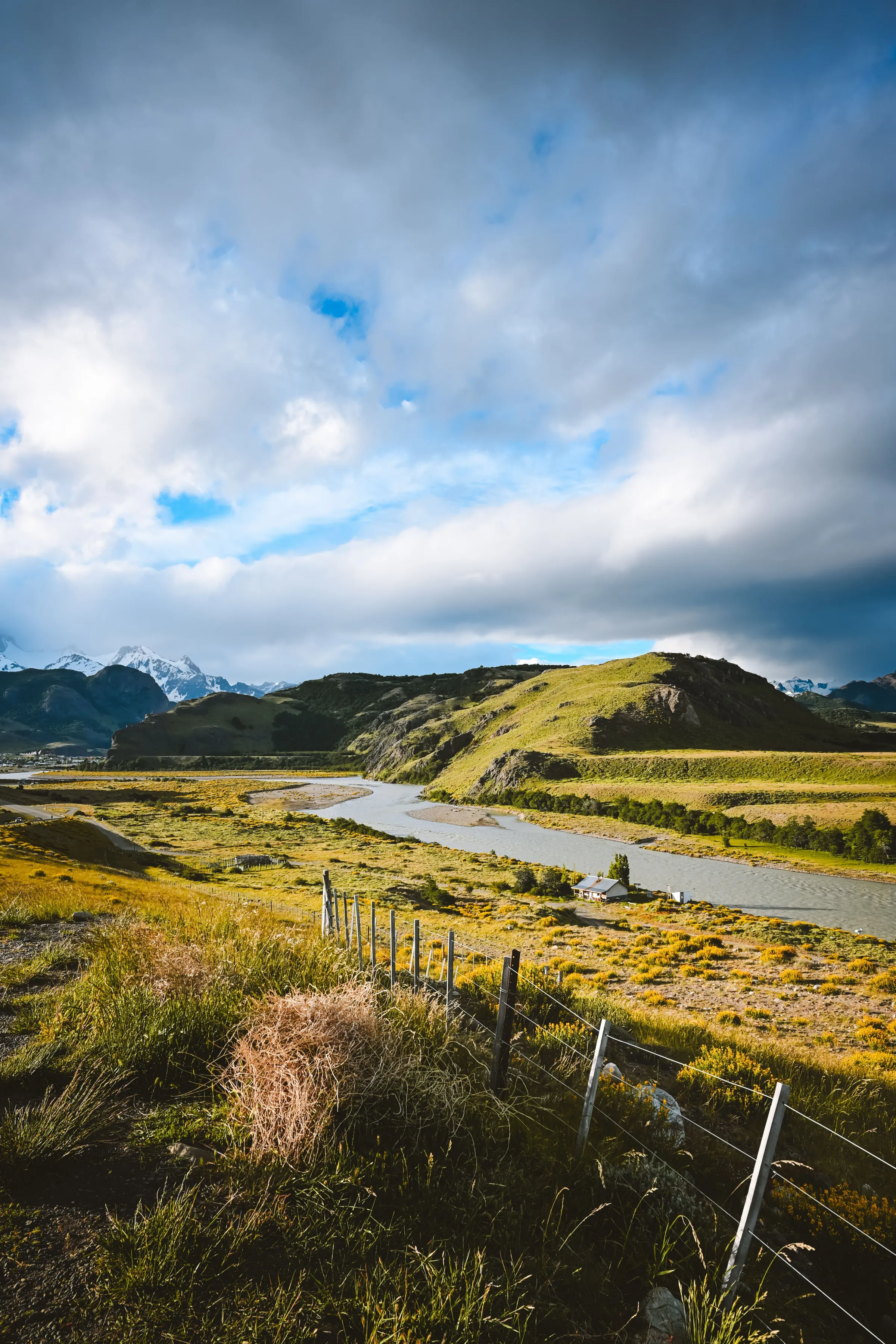 A winding river through an open valley beneath El Chaltén's mountains