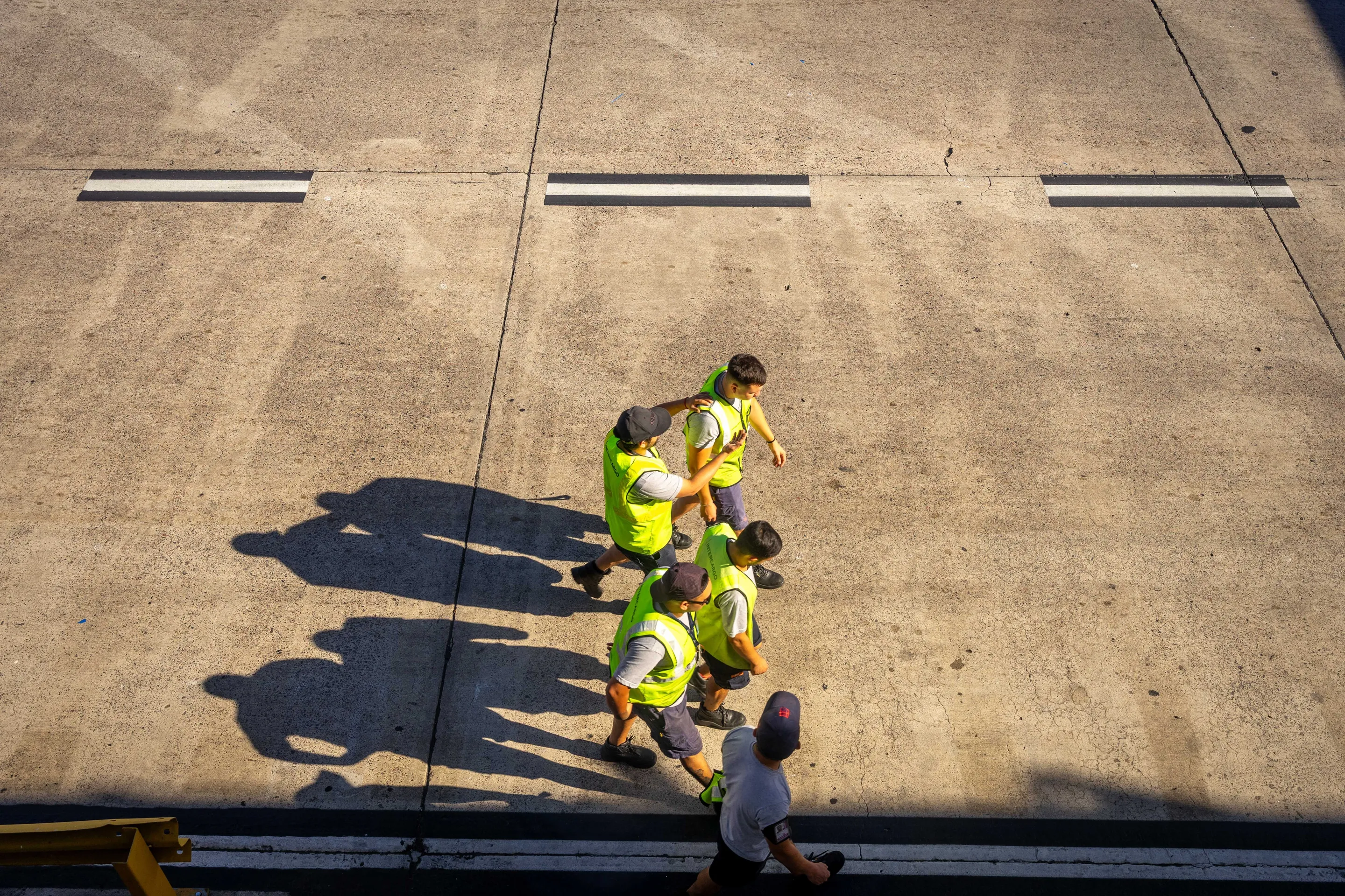 Airport workers crossing the tarmac in Buenos Aires.