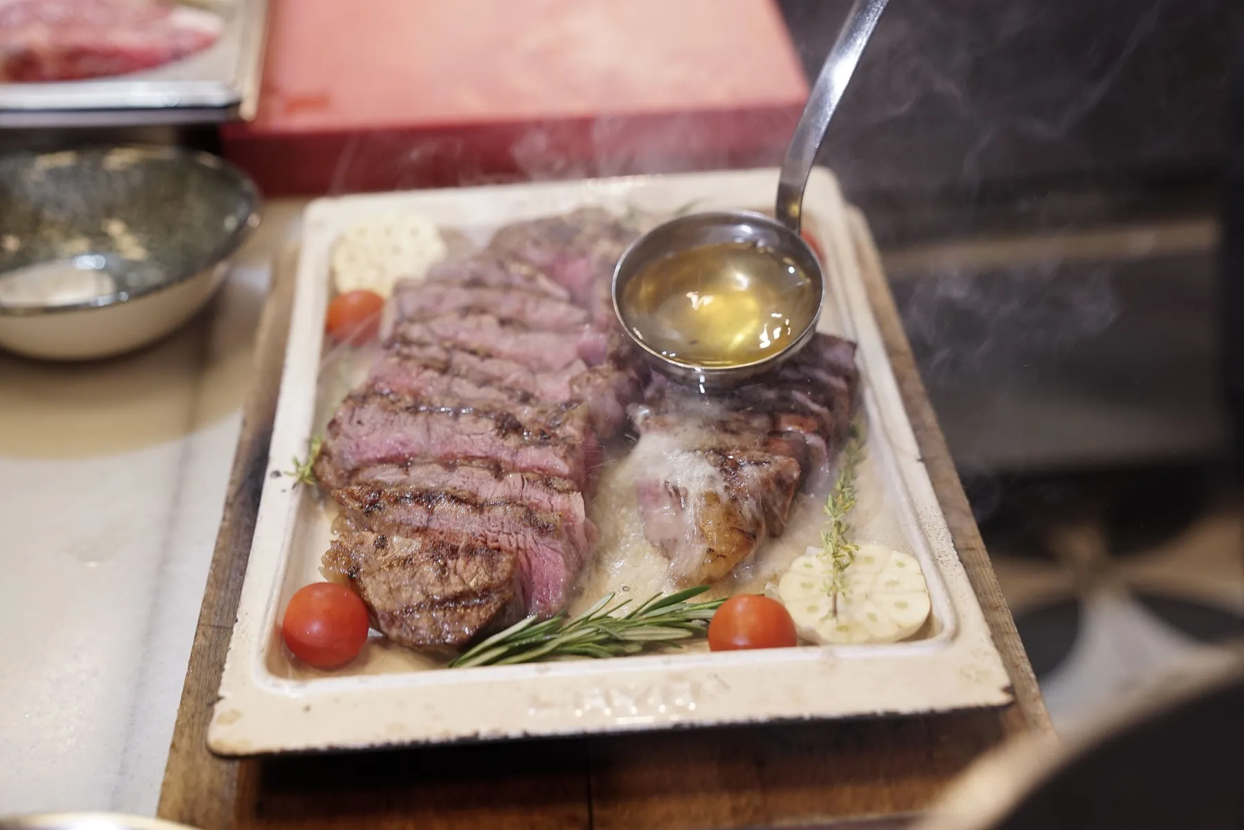 Sliced steak with rosemary and garlic as sauce is poured over it