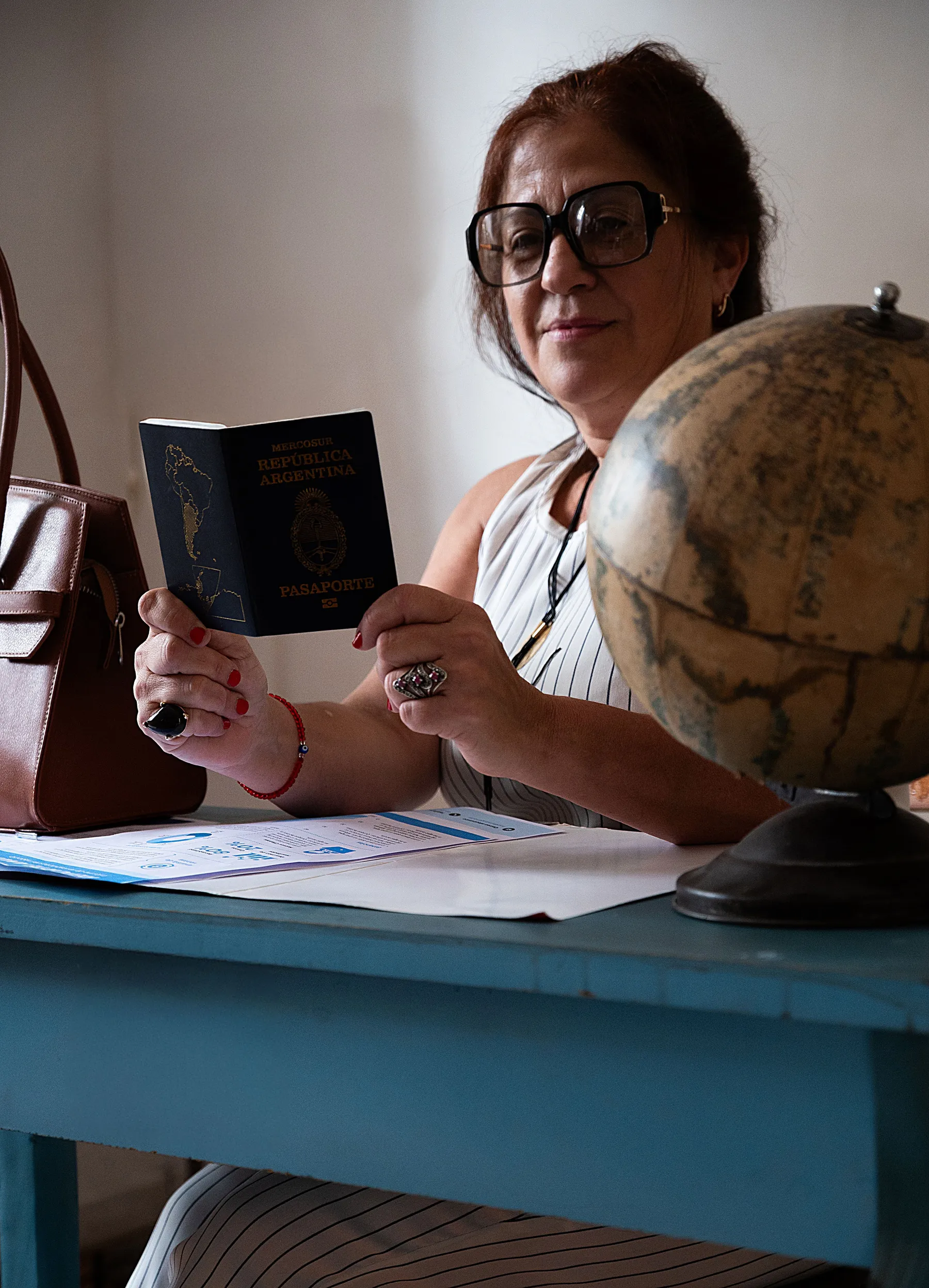 A passport and globe on a desk in Buenos Aires Province.