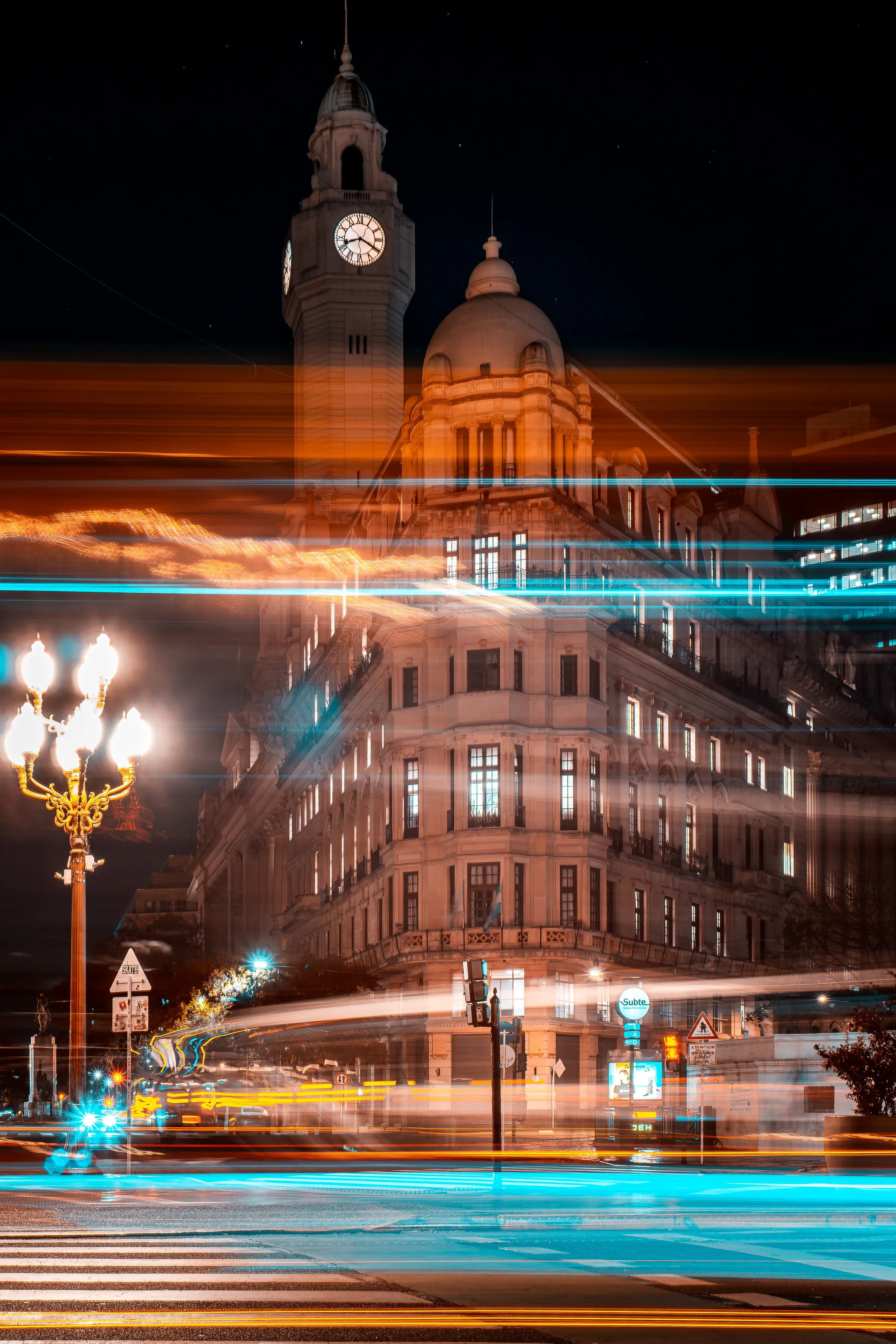 Historic Buenos Aires architecture illuminated above night-time traffic trails.