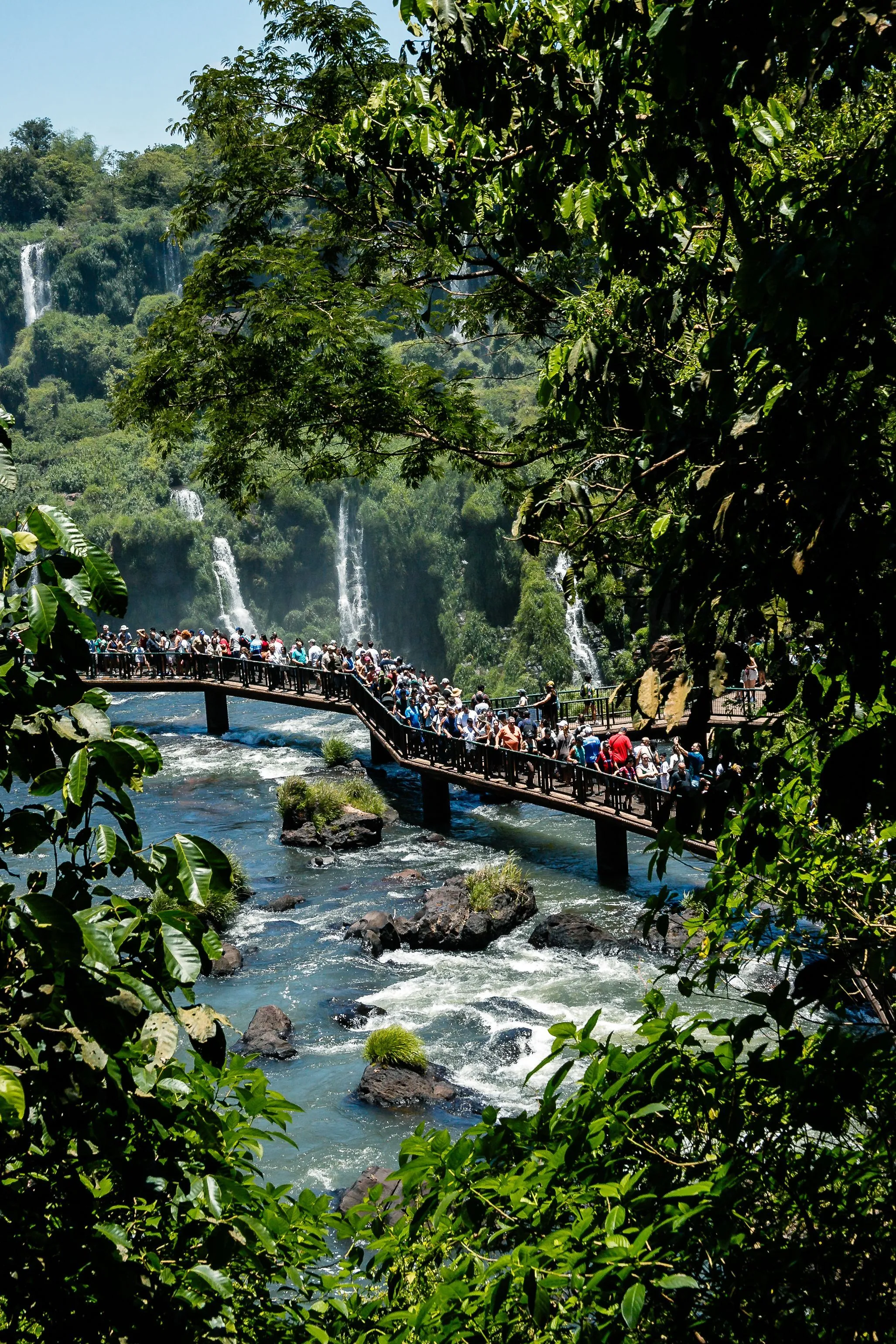 Visitors on a walkway beside the cascading waters of Iguazú Falls.