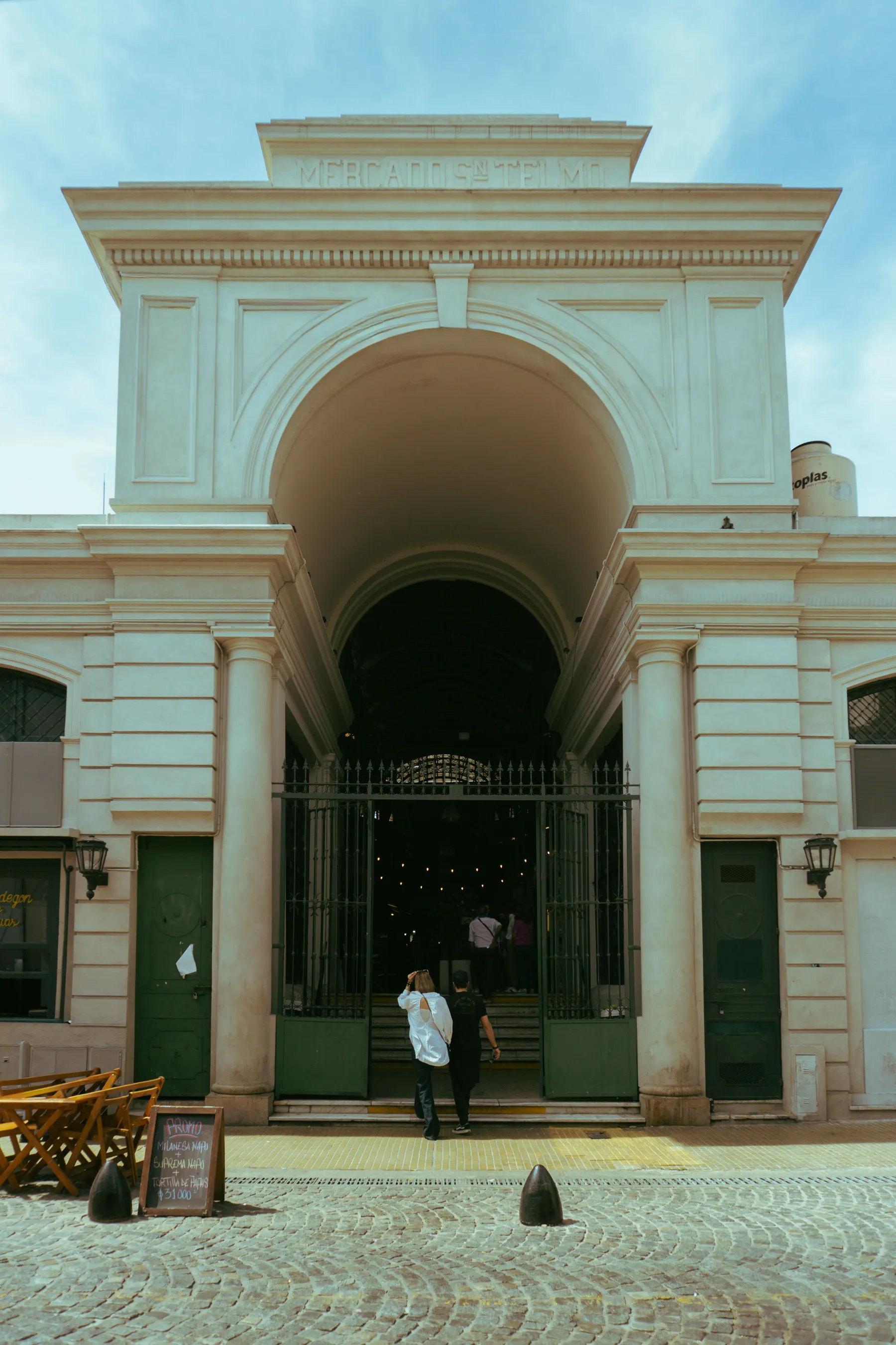 People entering the Mercado de San Telmo through its monumental arch
