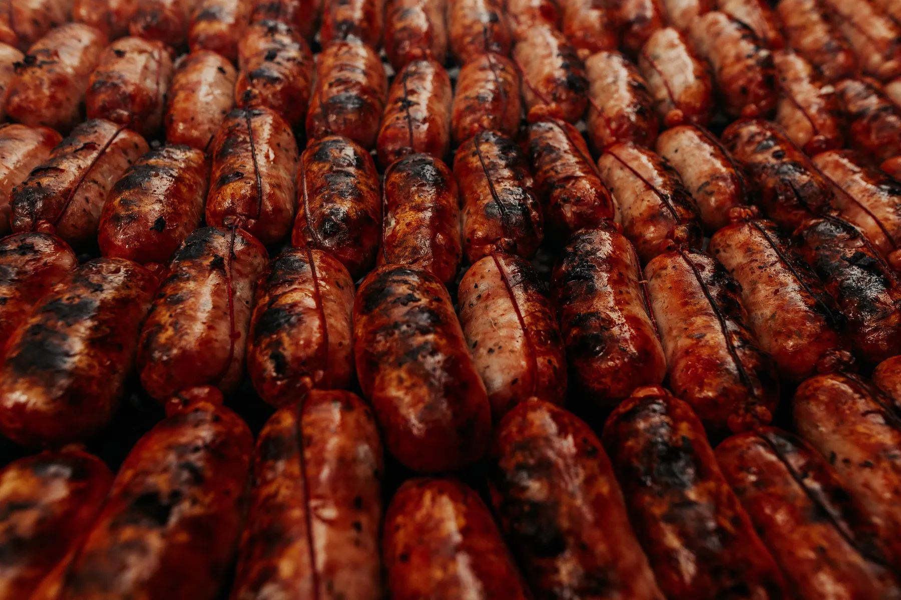 A close view of browned Argentine chorizo with dark grill marks