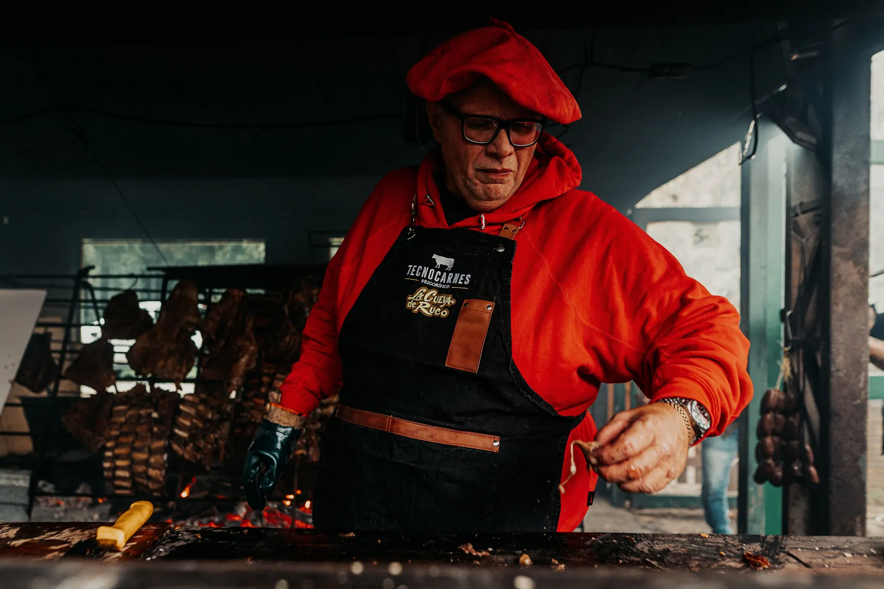 An asador working beside a grill in Buenos Aires Province