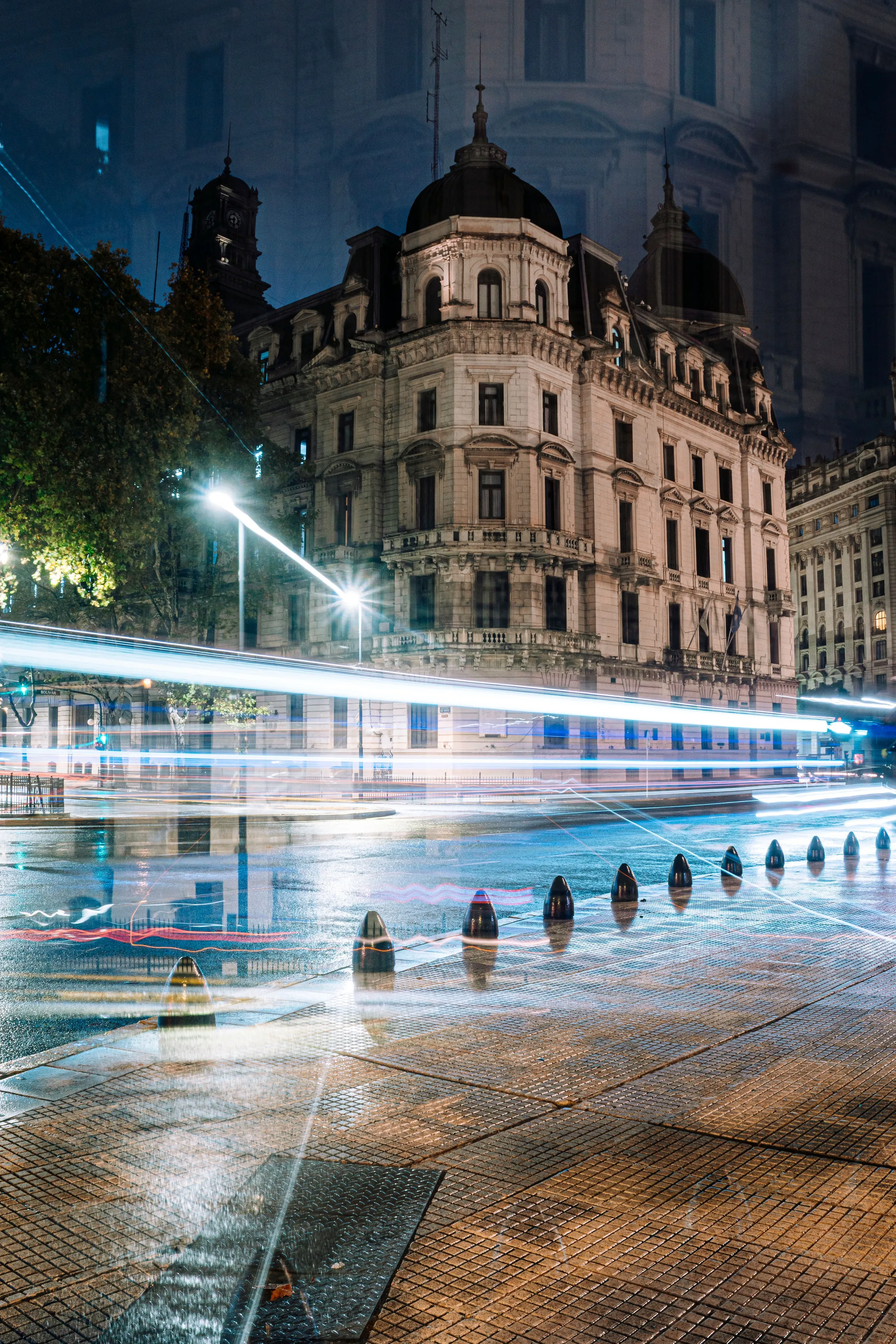 Historic Buenos Aires architecture and passing traffic in the night light.
